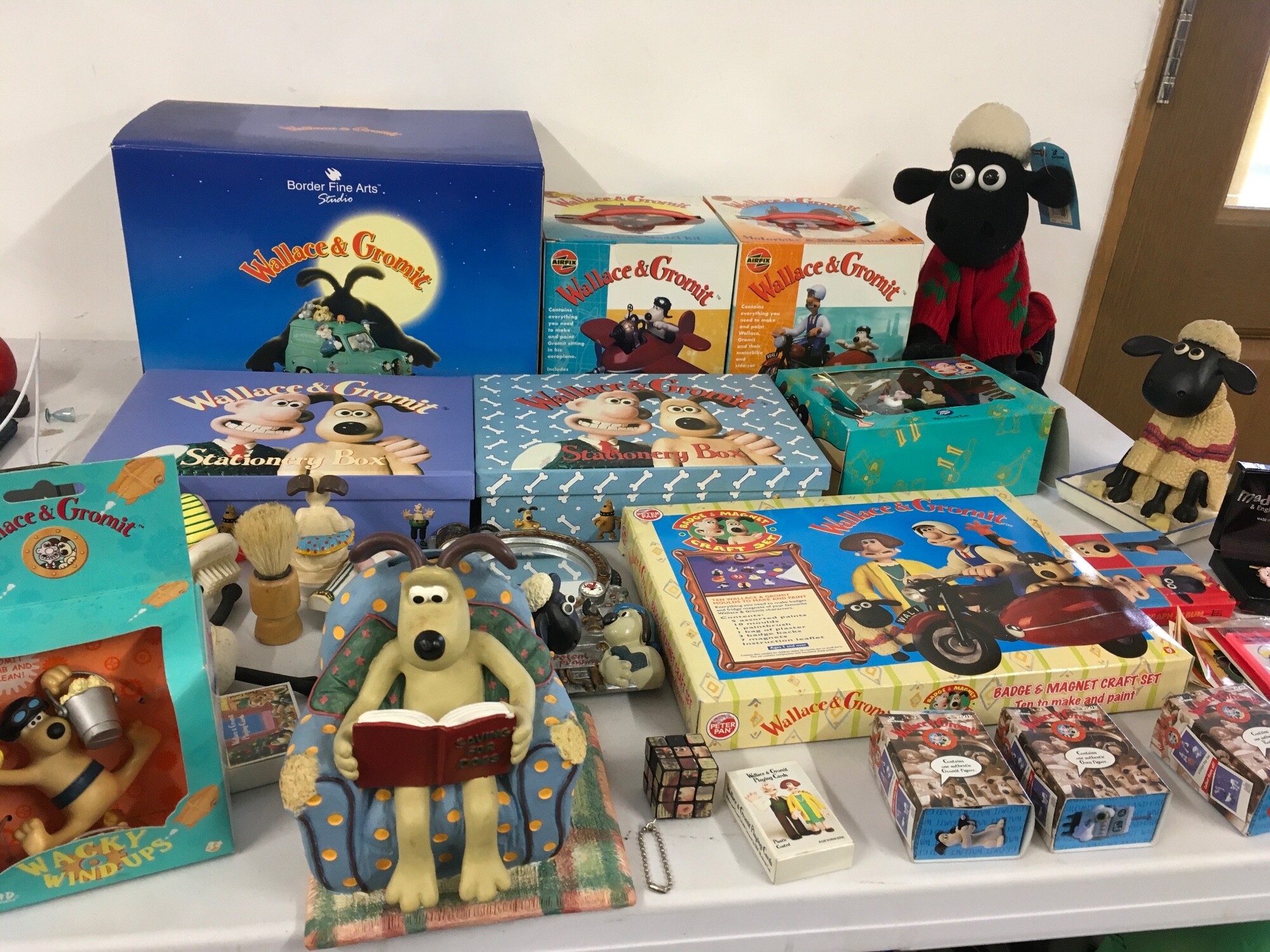 A varied collection of Wallace and Gromit merchandise including, saving bank, display figures, cuff links, stationery sets  etc.  no reserve