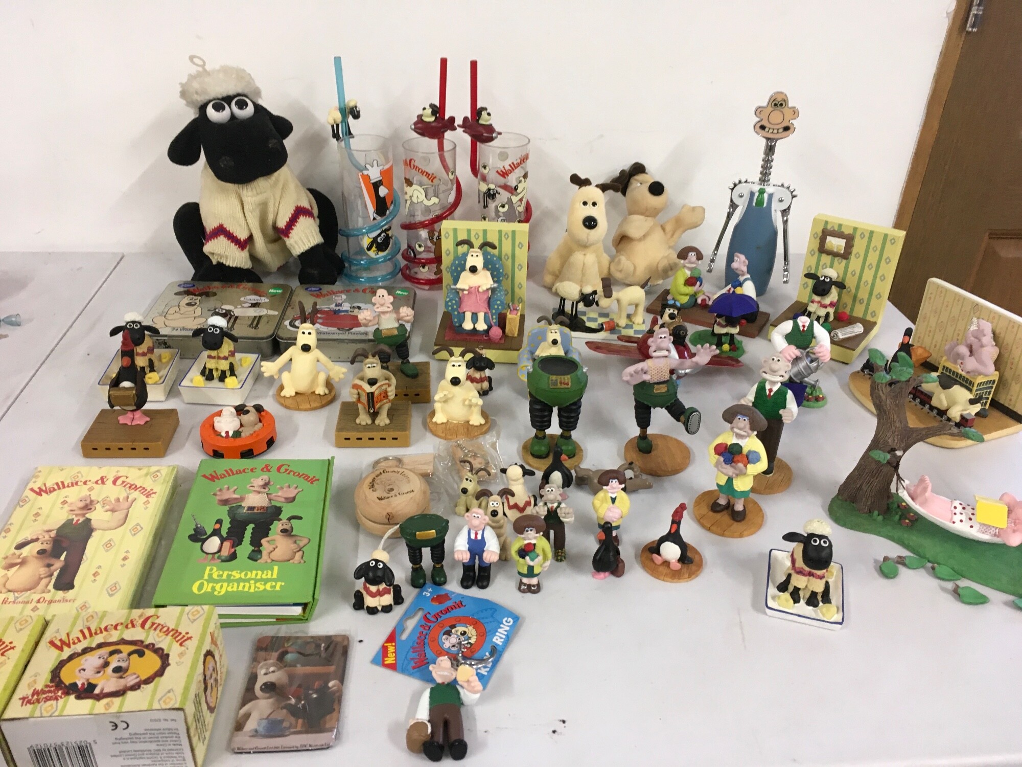 A large varied collection of Wallace and Gromit merchandise including display figures, personal organisers, bottle cork remover plus other items.  No reserve