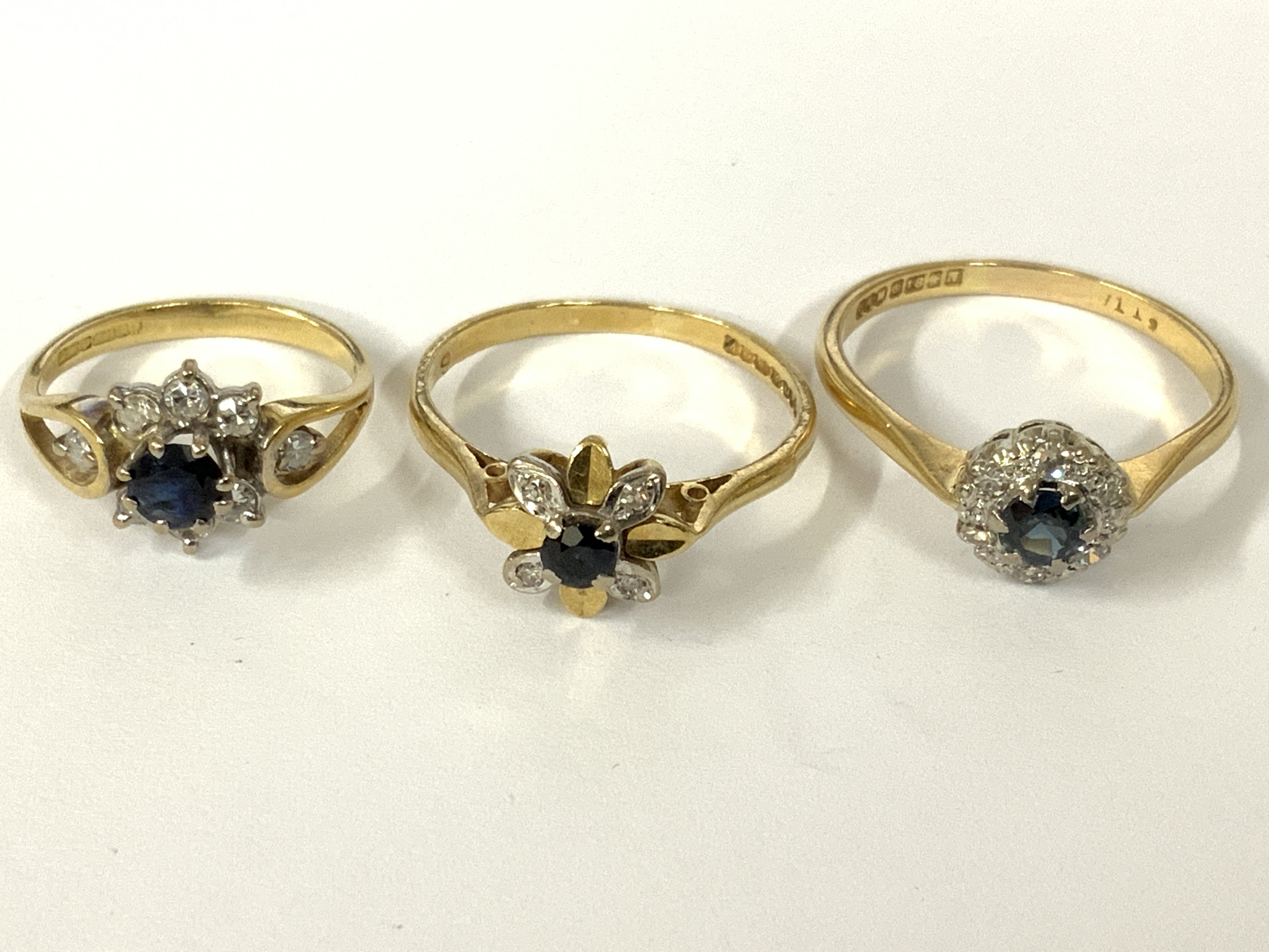 Three 18ct gold sapphires / diamond cluster rings. Approx ring size F, N, P. Approx 7.1g. Postage category A