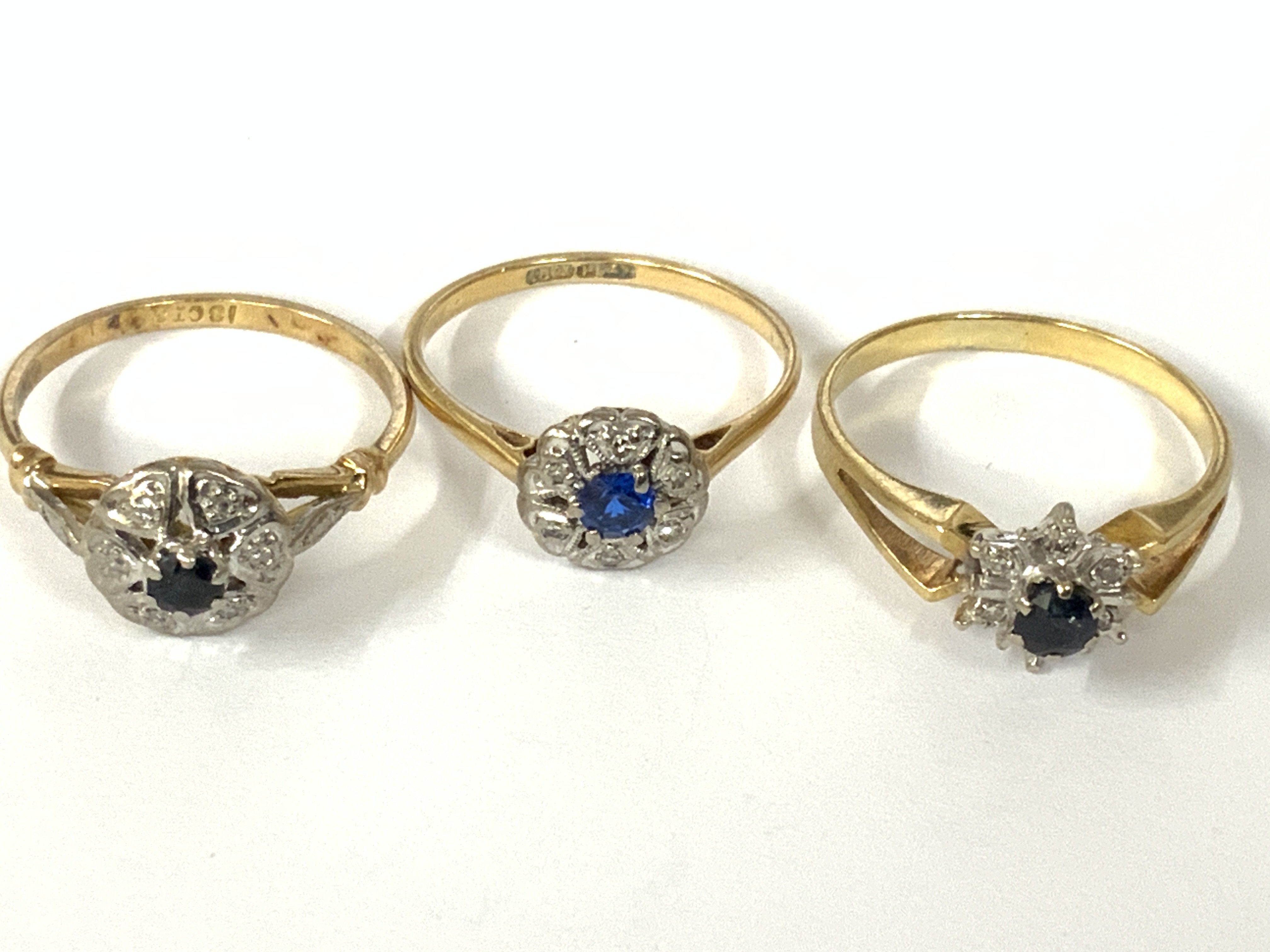 Three 18ct gold sapphire / diamond cluster rings. Approx ring size O,P. Approx 8.5g. Postage category A