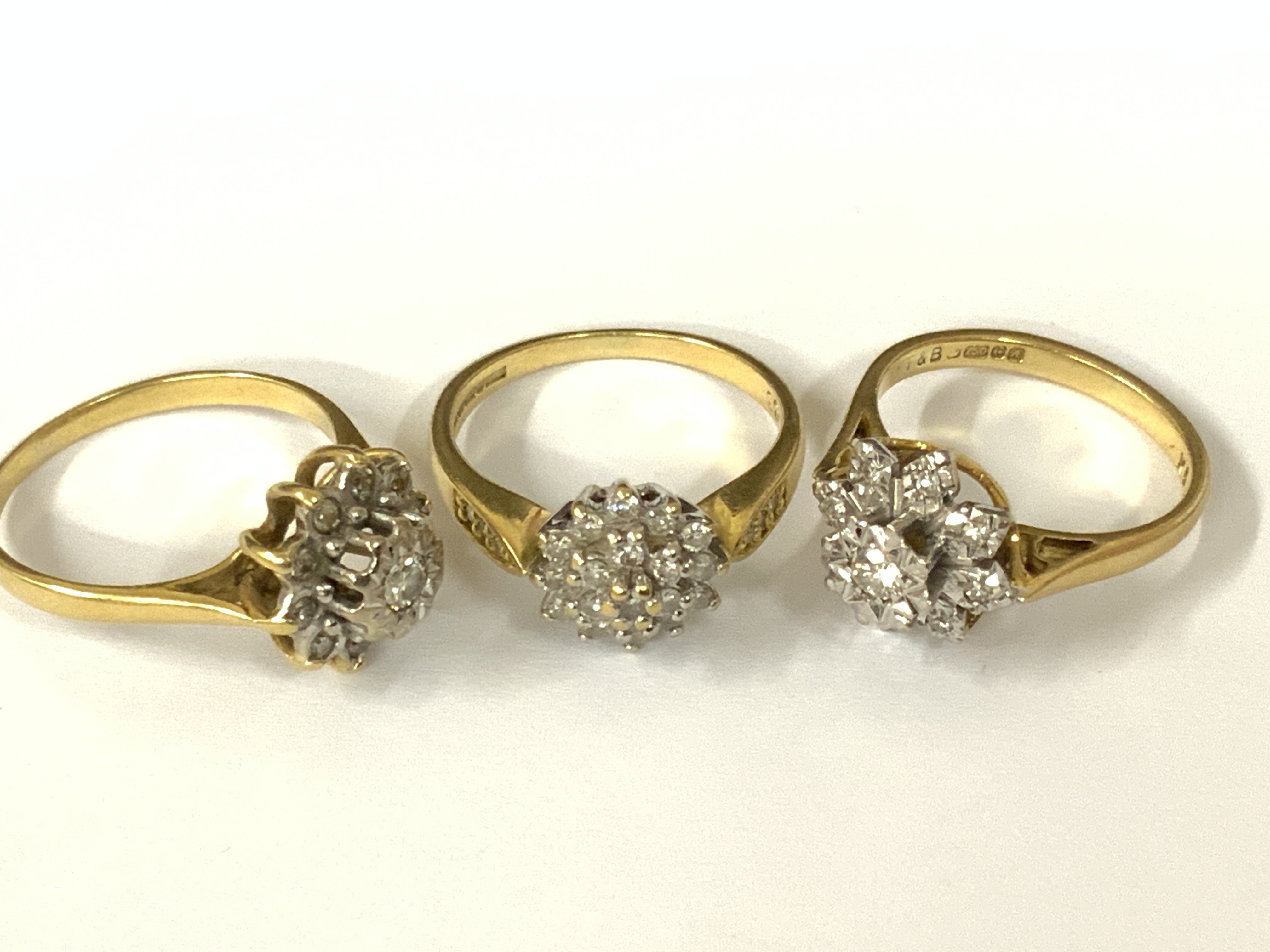 Three 18ct gold diamond cluster rings. Approx ring size K,M,O. Approx 10.9g. Postage category A