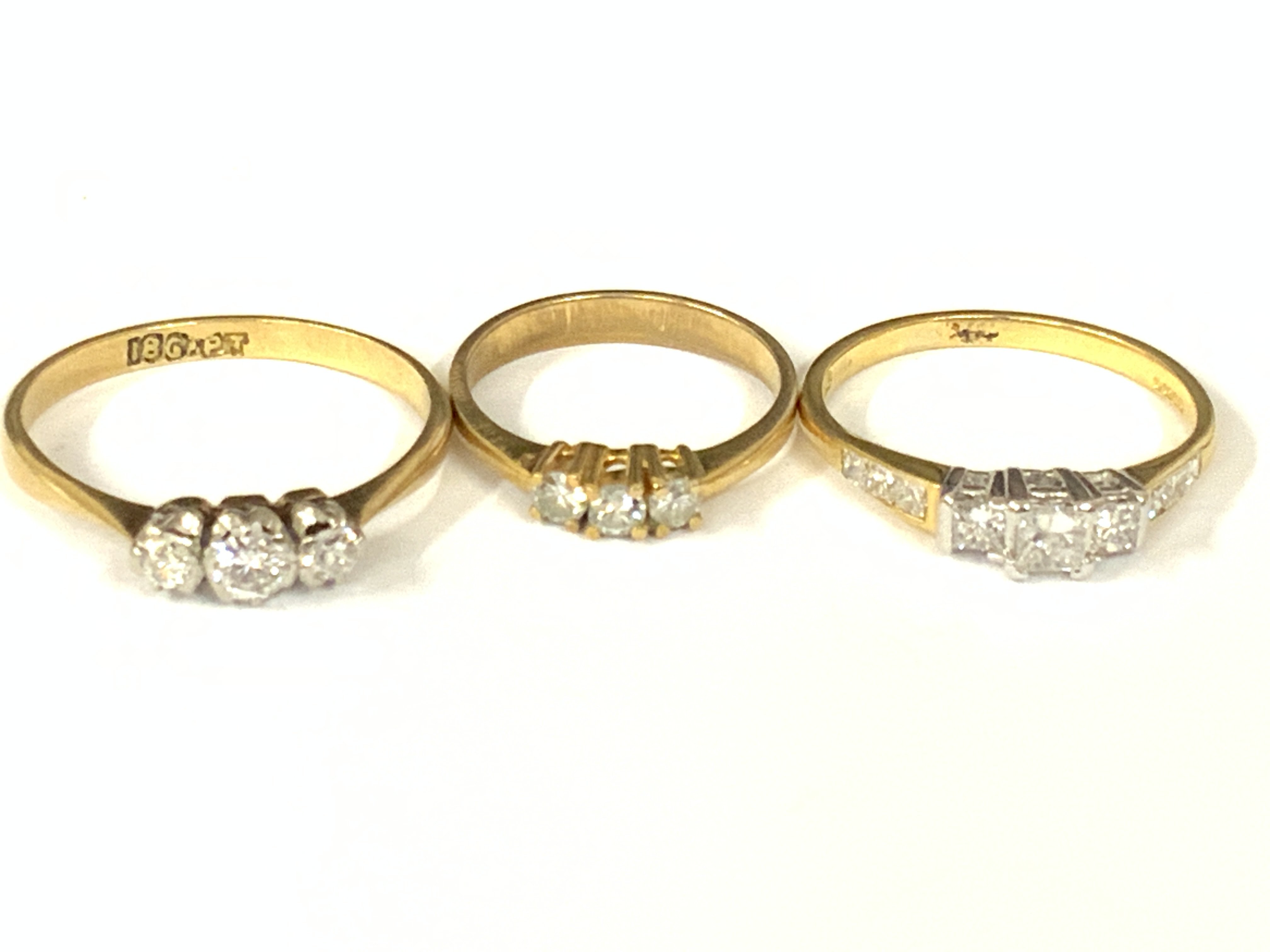 Three 18ct gold three stone diamond rings. Approx ring size G,N,Q. Approx 6.4g. Postage category A