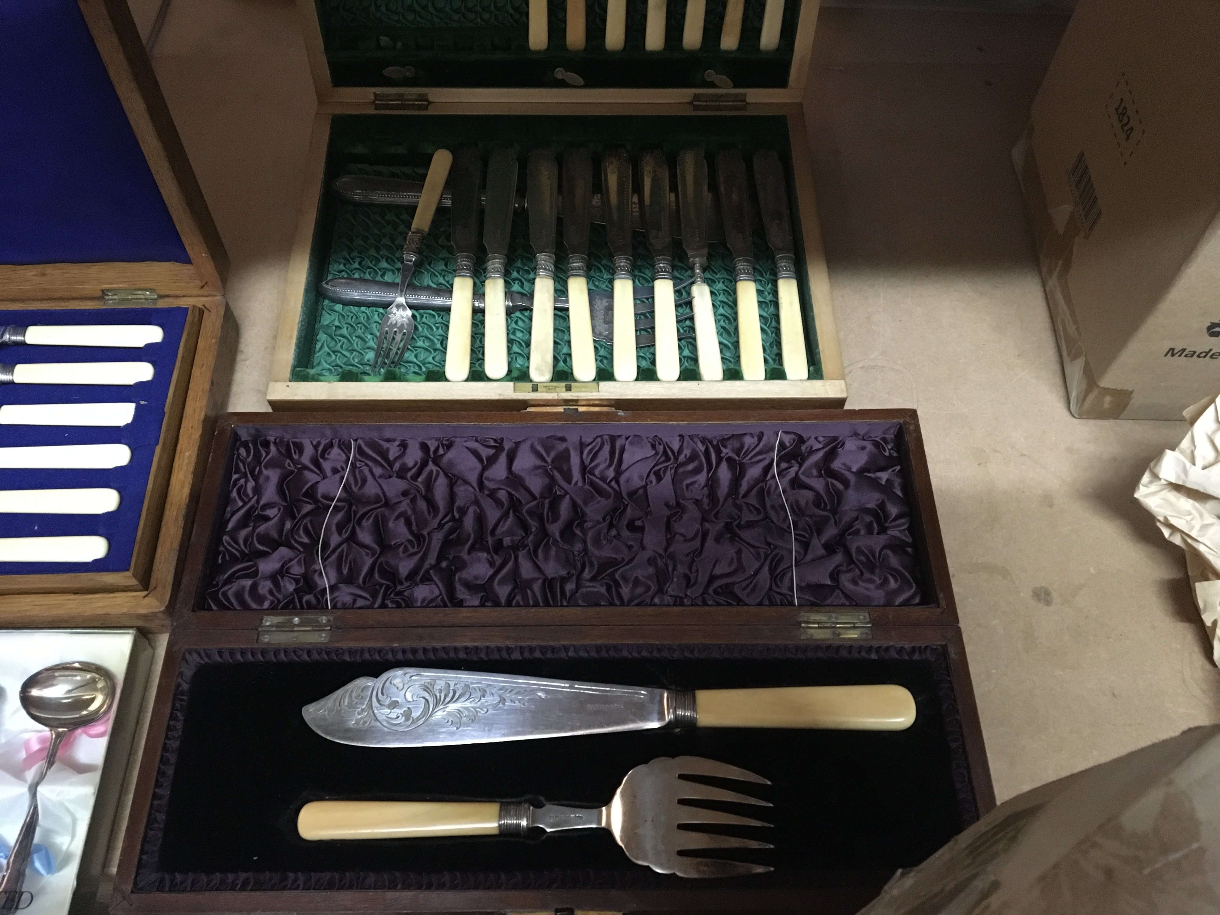 A collection of cased cutlery including silver handle knives and a cased set of spoons .