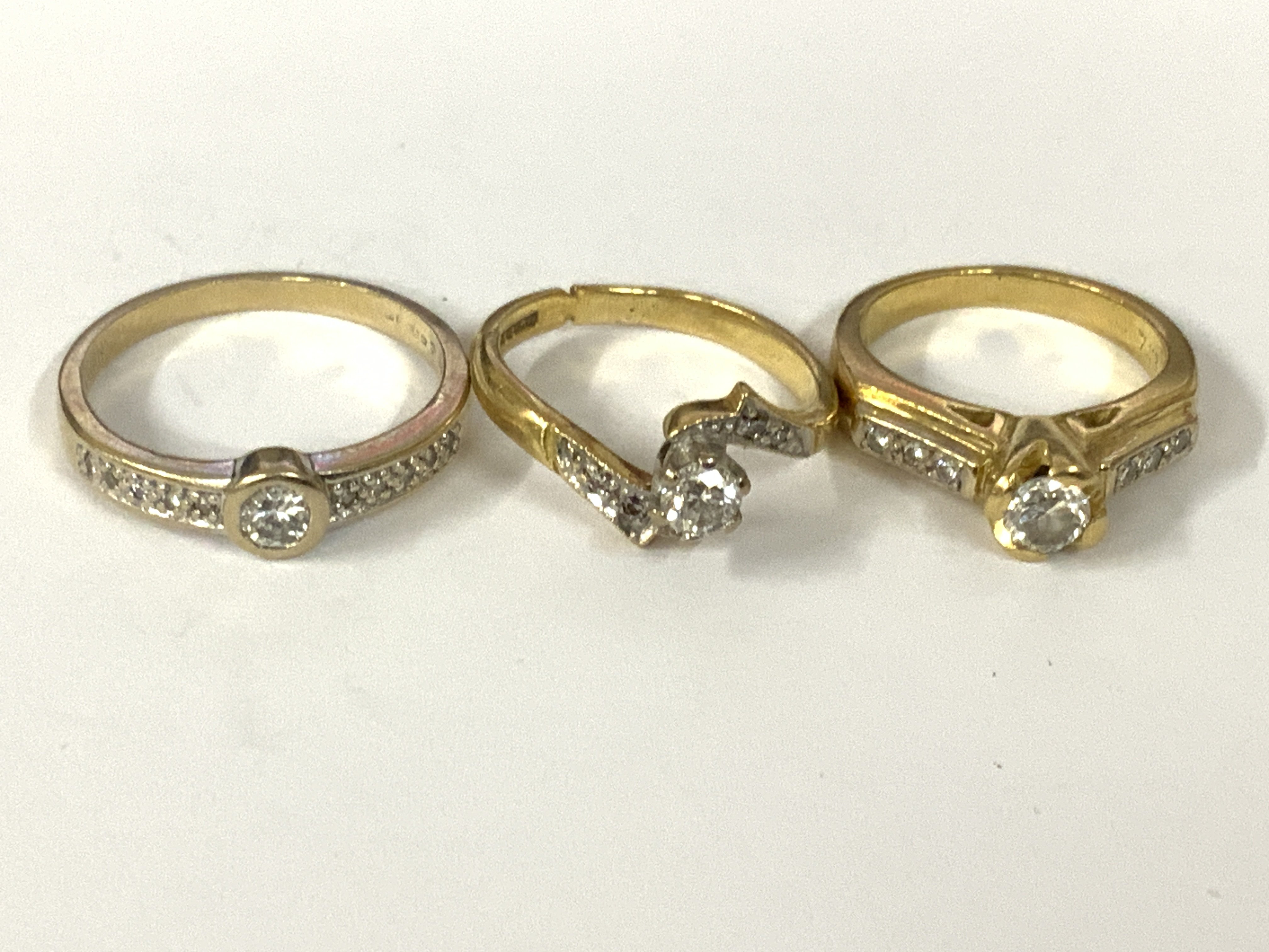 Three 18ct gold diamond solitaires with diamond shoulders. Approx ring size I,L,O. Approx 11.9g. Postage category A