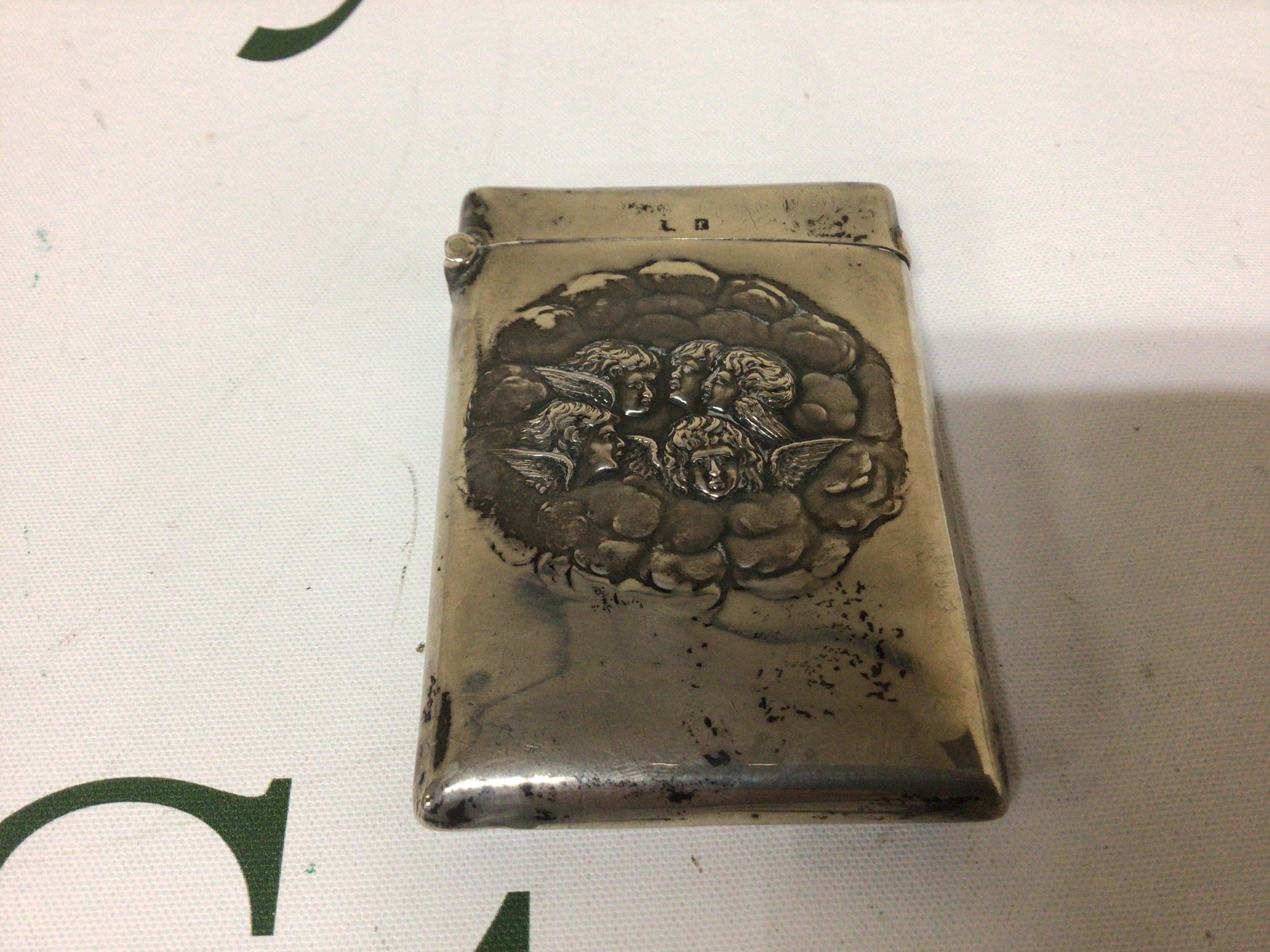 A Silver card Case decorated with winged cherubs amounts clouds. Birmingham hallmarks.
