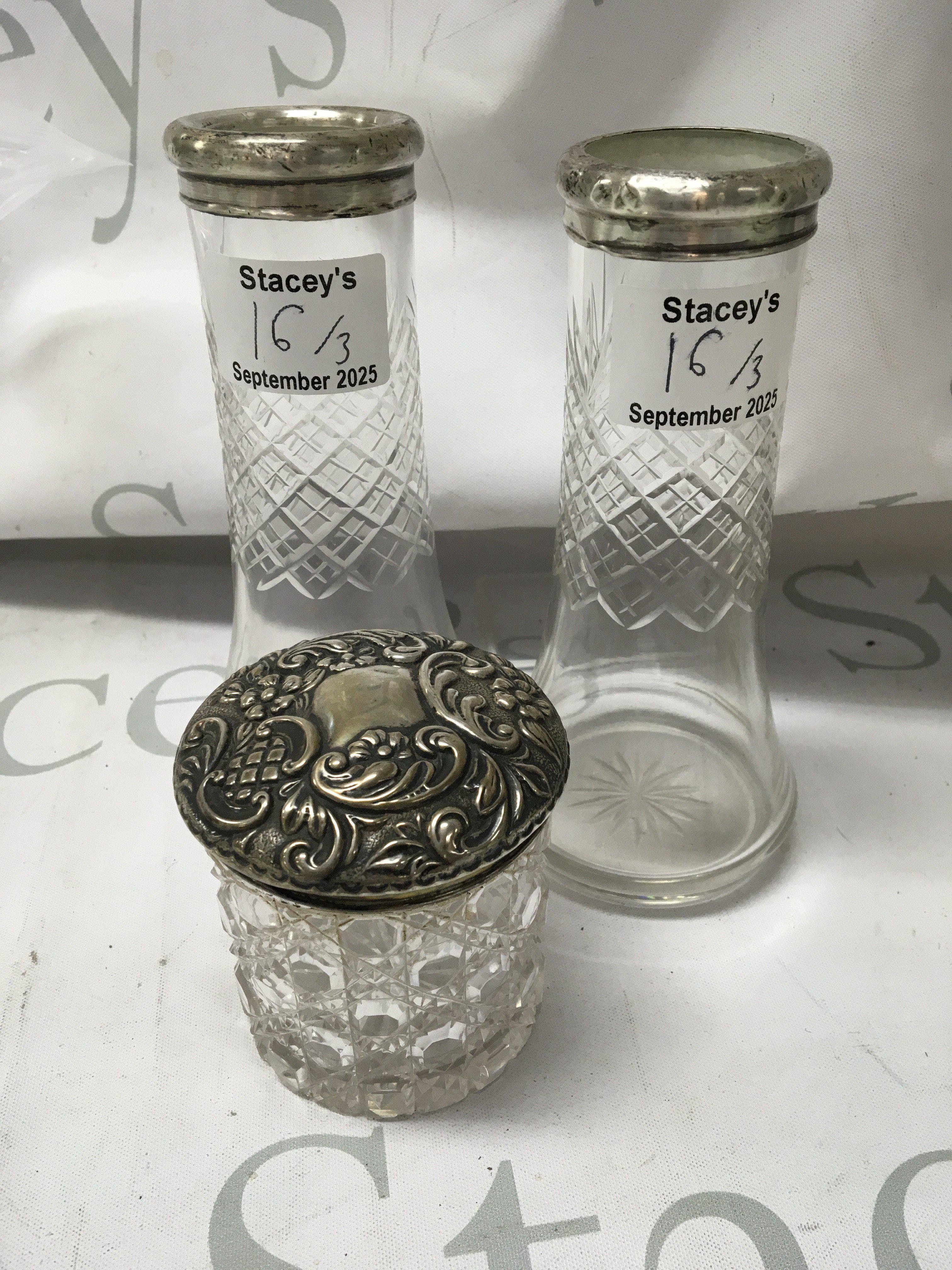 A pair of silver rim glass vases and a tidy jar with silver lid .