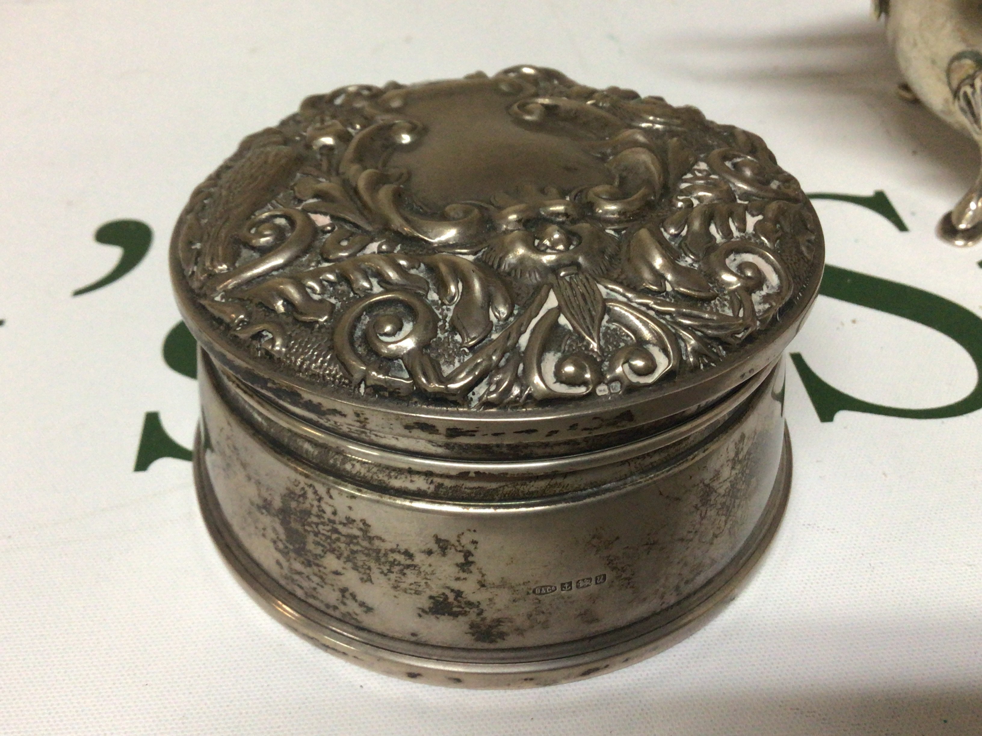 A Silver Jewellery box of circular shape Birmingham hallmarks with a Repousse chased hinged lid velvet lined.