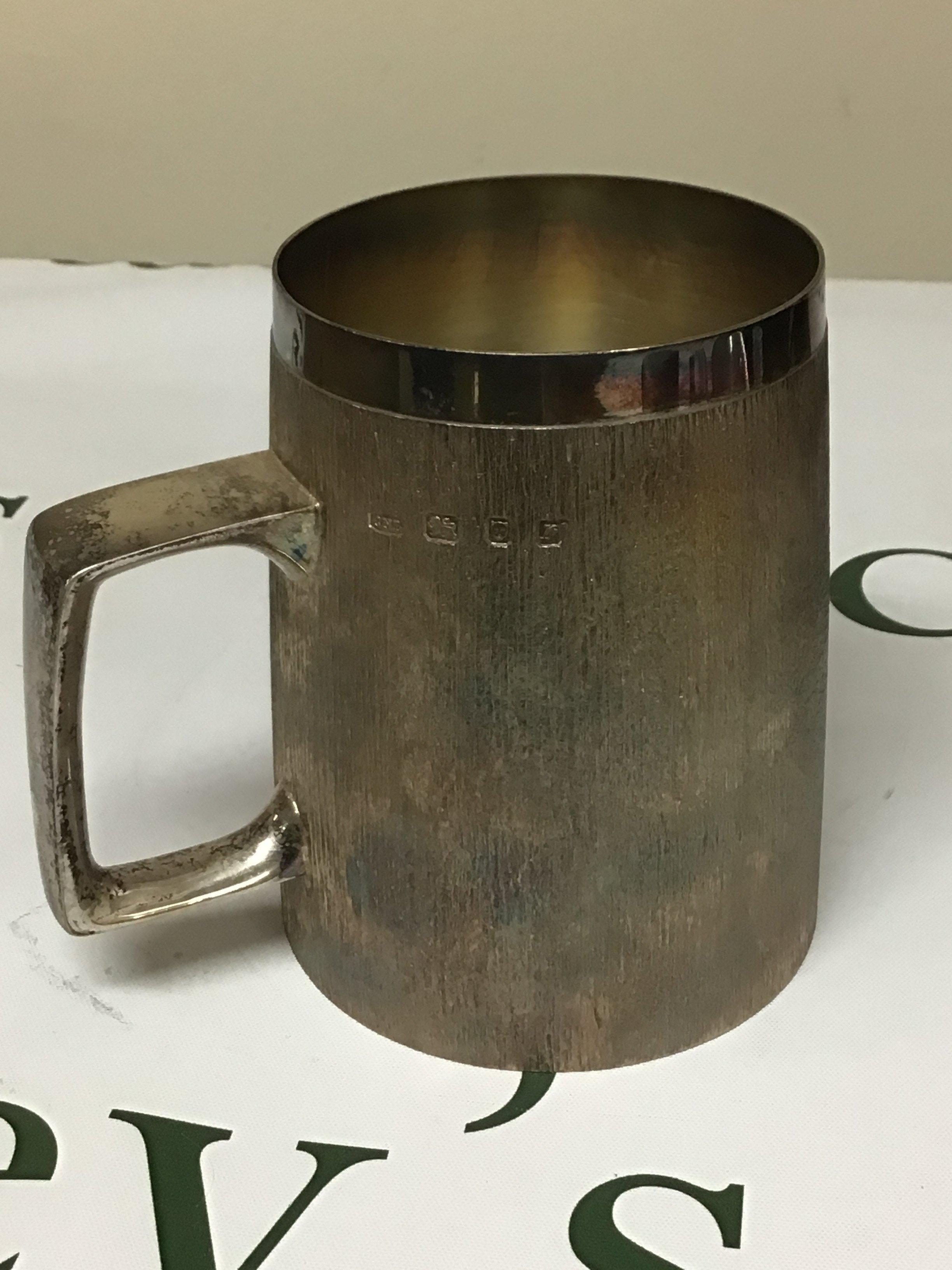 A Mid 20th Century modern design silver mug by Christopher Lawrence (b1936) Liveryman for the Worshipful Goldsmith Company Studied Central School of Arts & Crafts. The silver mug with a textured finish London hallmarks makers stamp very good condition weight 495g height 12cm