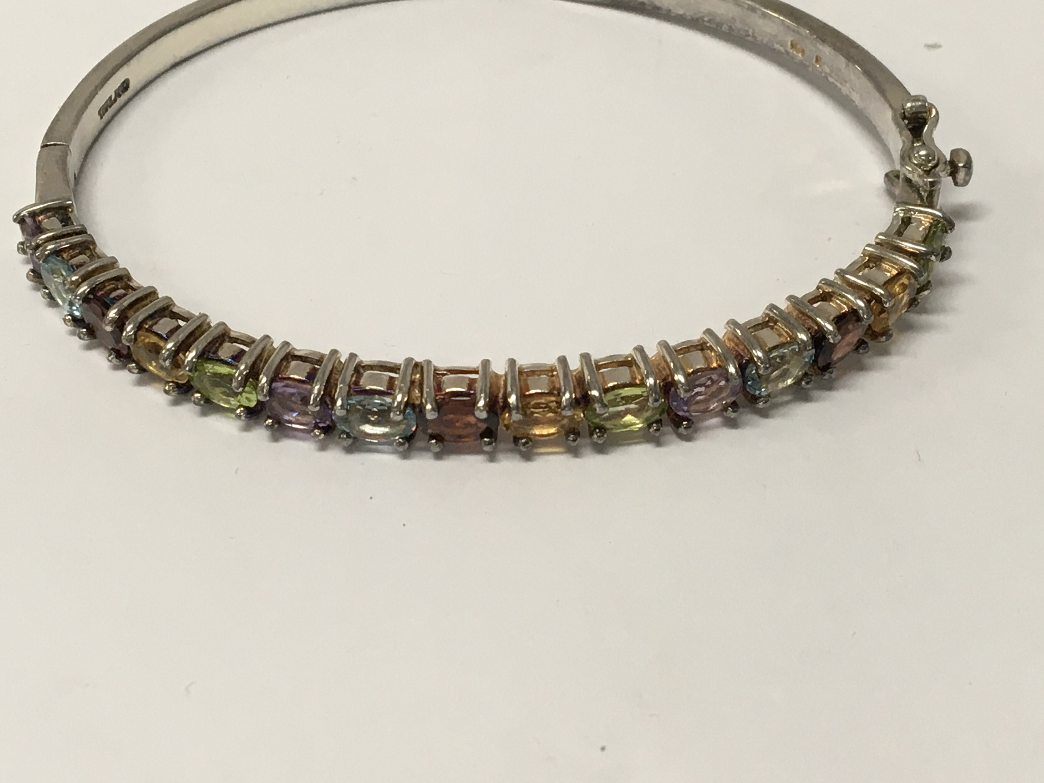 WITHDRAWN - A 9 ct gold bangle inset with multi gem stones .