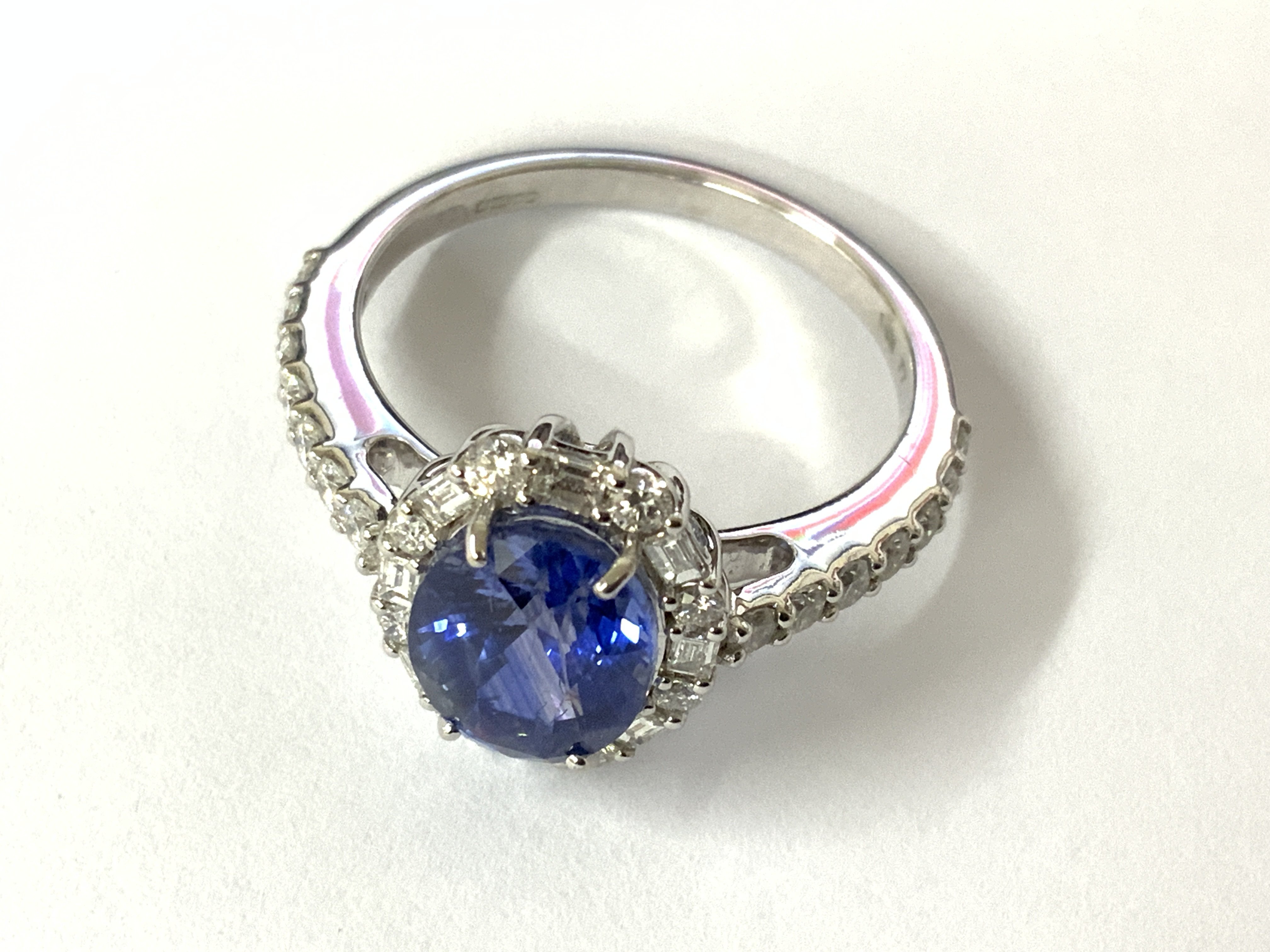 Certificated 18ct white gold oval sapphire and RBC and baguette cut diamond cluster ring with diamonds to the shoulders. Sapphire 2.50ct. Diamonds 0.60ct. Cert no. WGI9634154119. Approx N ring size. Postage category A.