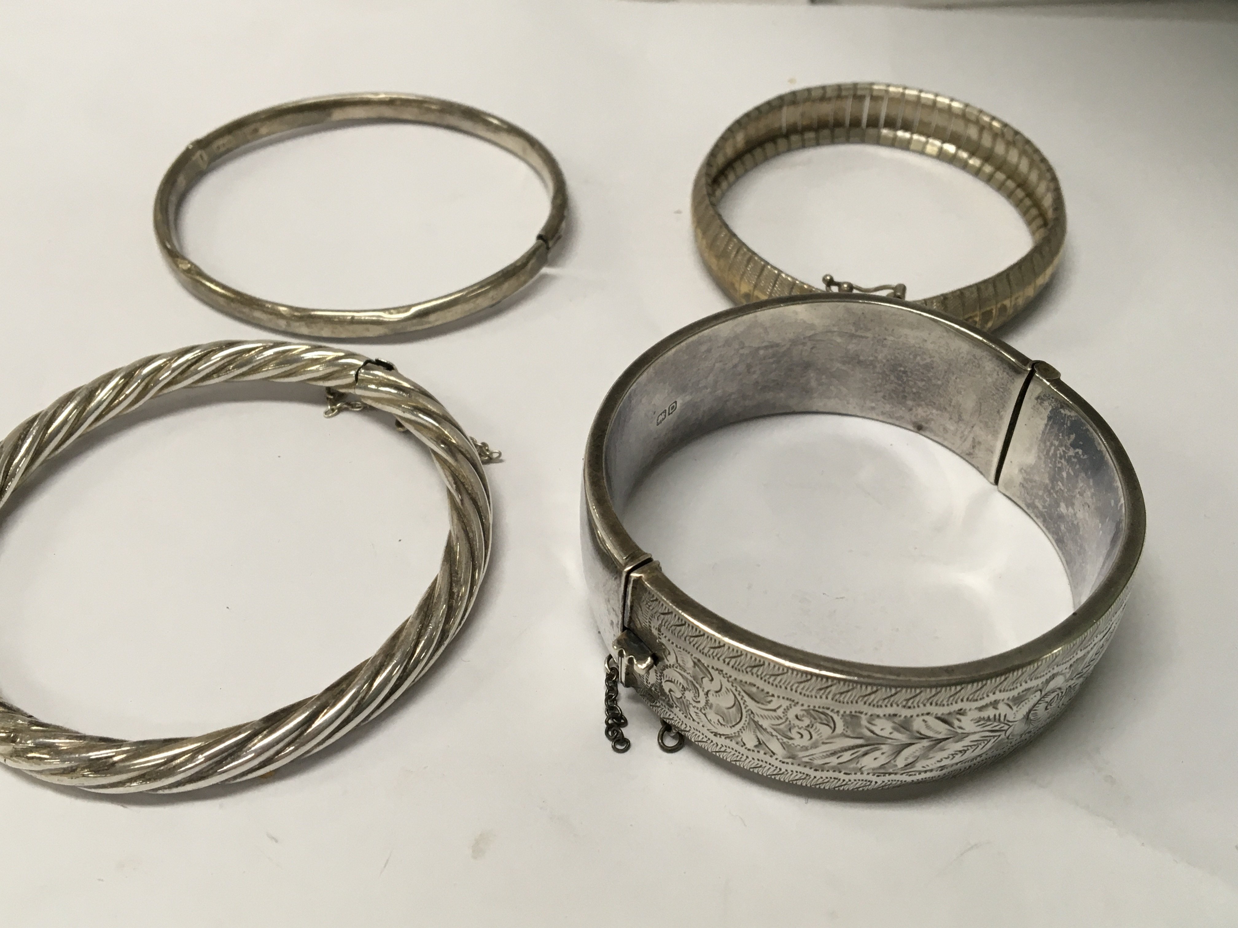A collection of four silver bangles .