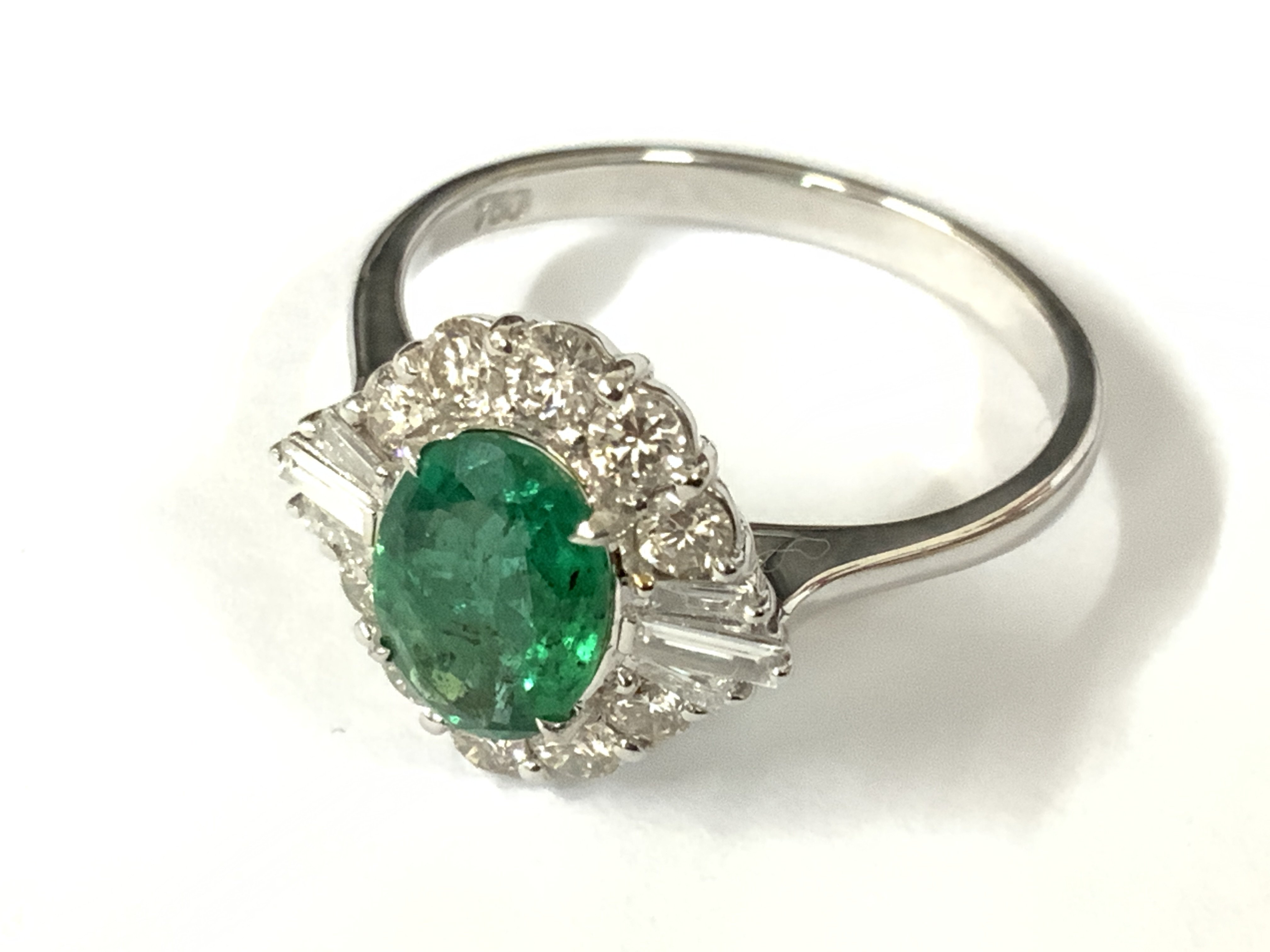 18ct white gold oval emerald and diamond cluster ring. Emerald 1.00ct. RBC and tapered baguette diamonds 0.60ct (RBC 0.48ct, tap bags 0.12ct) approx ring size O. Postage category A