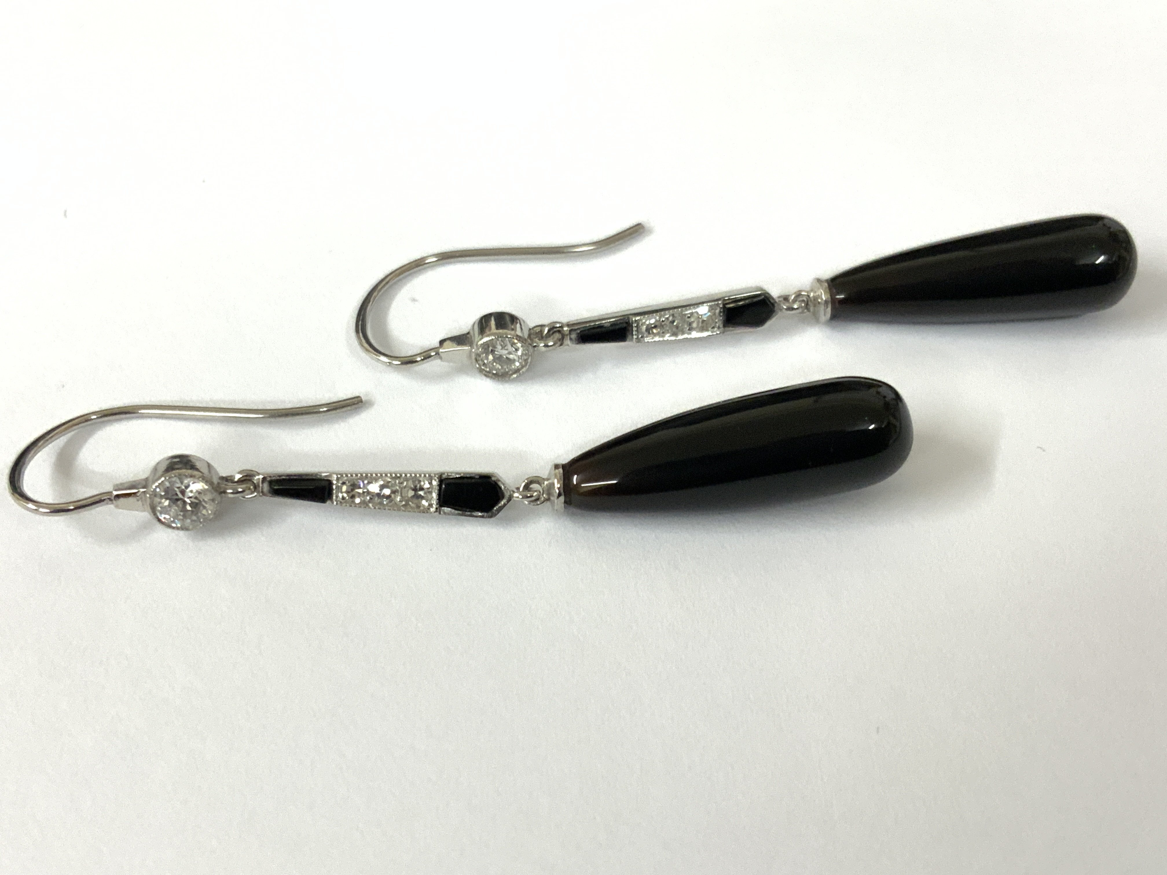 Pair drop earrings set with onyx and diamonds with fish hook backs. Postage category A
