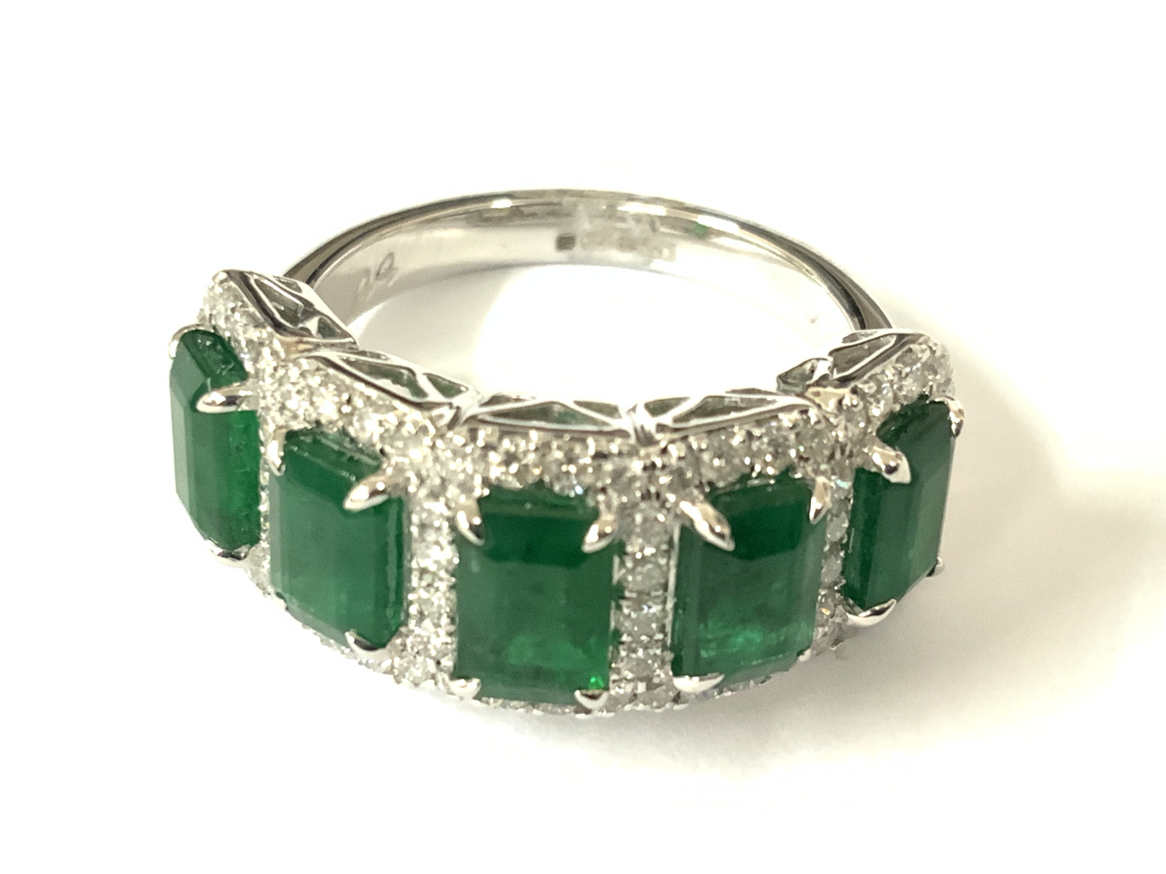Platinum cluster ring set with 5 step cut emerald each surrounds by RBC diamonds. Emeralds 2.86ct. Diamonds 0.67ct. Approx ring size L. Postage category A