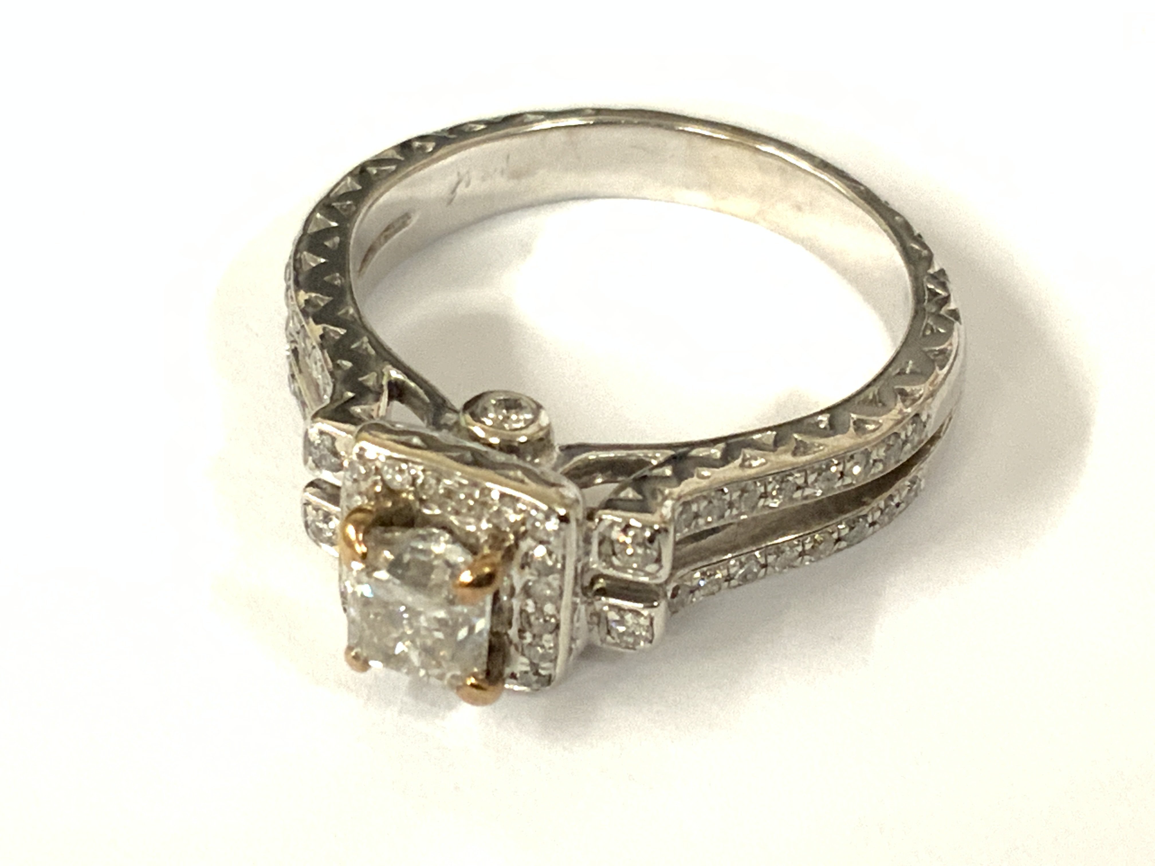 Stylish 14ct white gold ring set with a central princess cut diamond surrounded by RBC diamonds, with further RBC diamond set to the sides and split design shoulders. Diamonds 1.p0ct approx. Approx ring size O. Postage category A