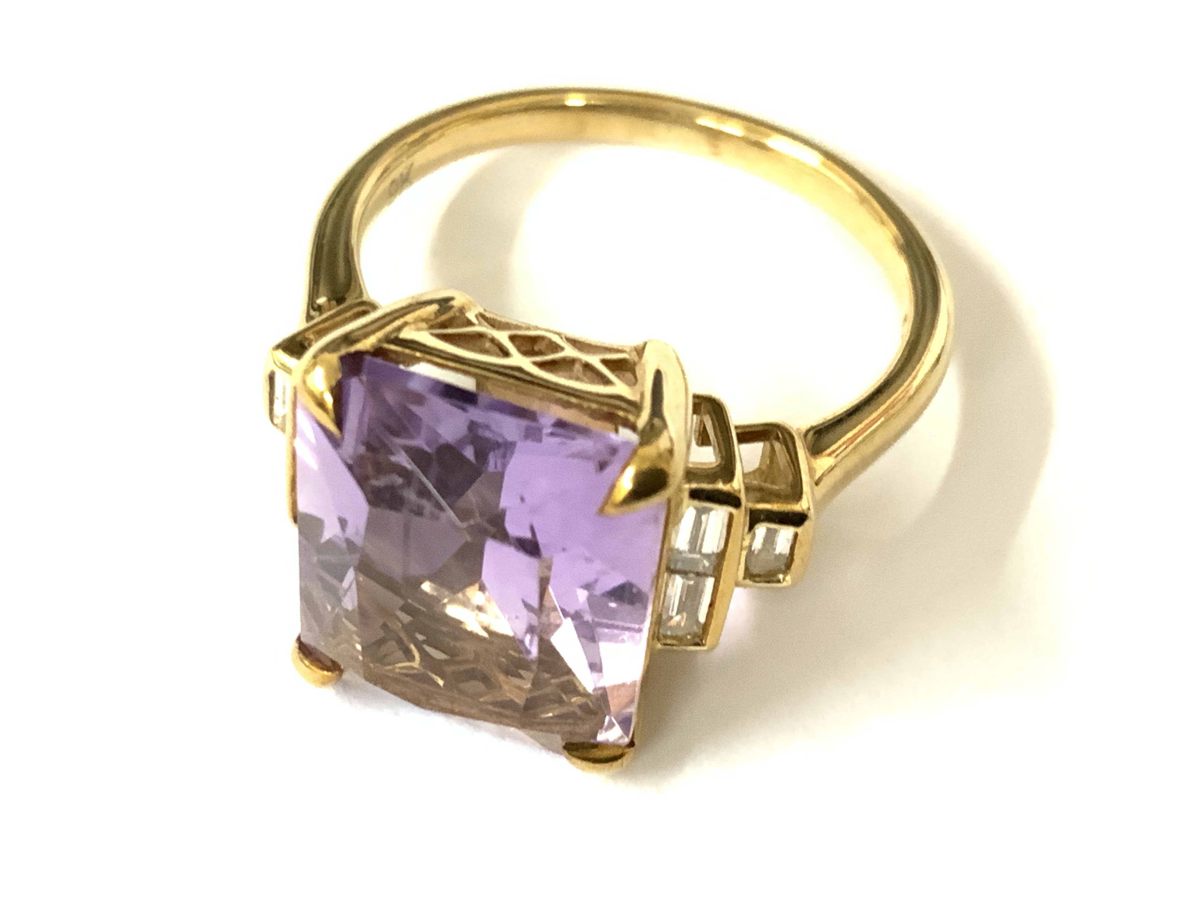 Stylish 9ct yellow gold ring set with a large rectangular amethyst flanked by baguette diamonds. Amethyst 5.68ct. Diamonds 0.23ct. Approx ring size N. Postage category A