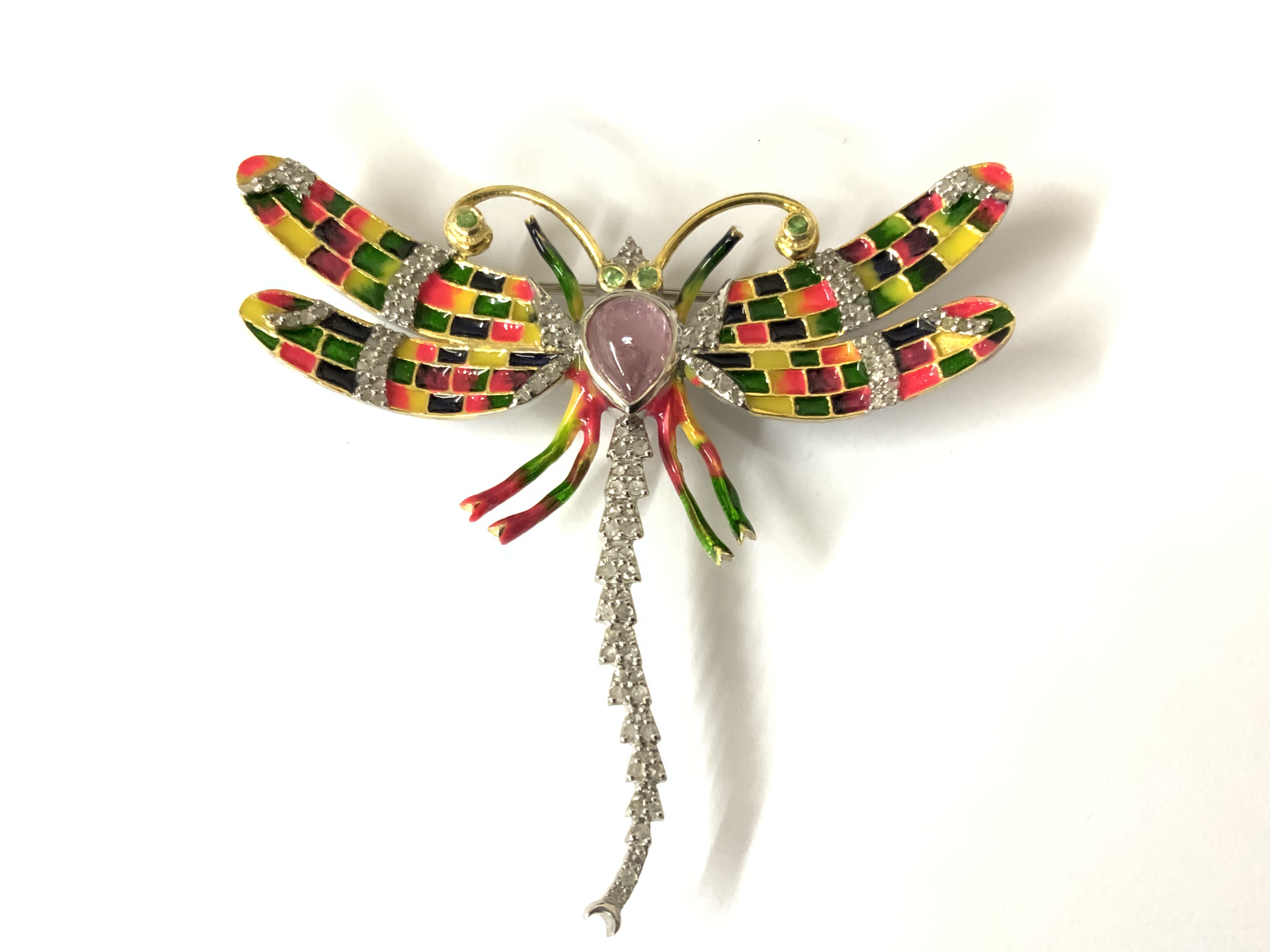 Silver dragonfly brooch and pendant (combined) set with a pear shaped tourmaline, tsavorite garnets and diamonds, with enamel inlays in colours of orange, green, purple and yellow. Diamonds 0.52ct. Tourmaline 1.16ct. Garnet 0.07ct. Postage category A