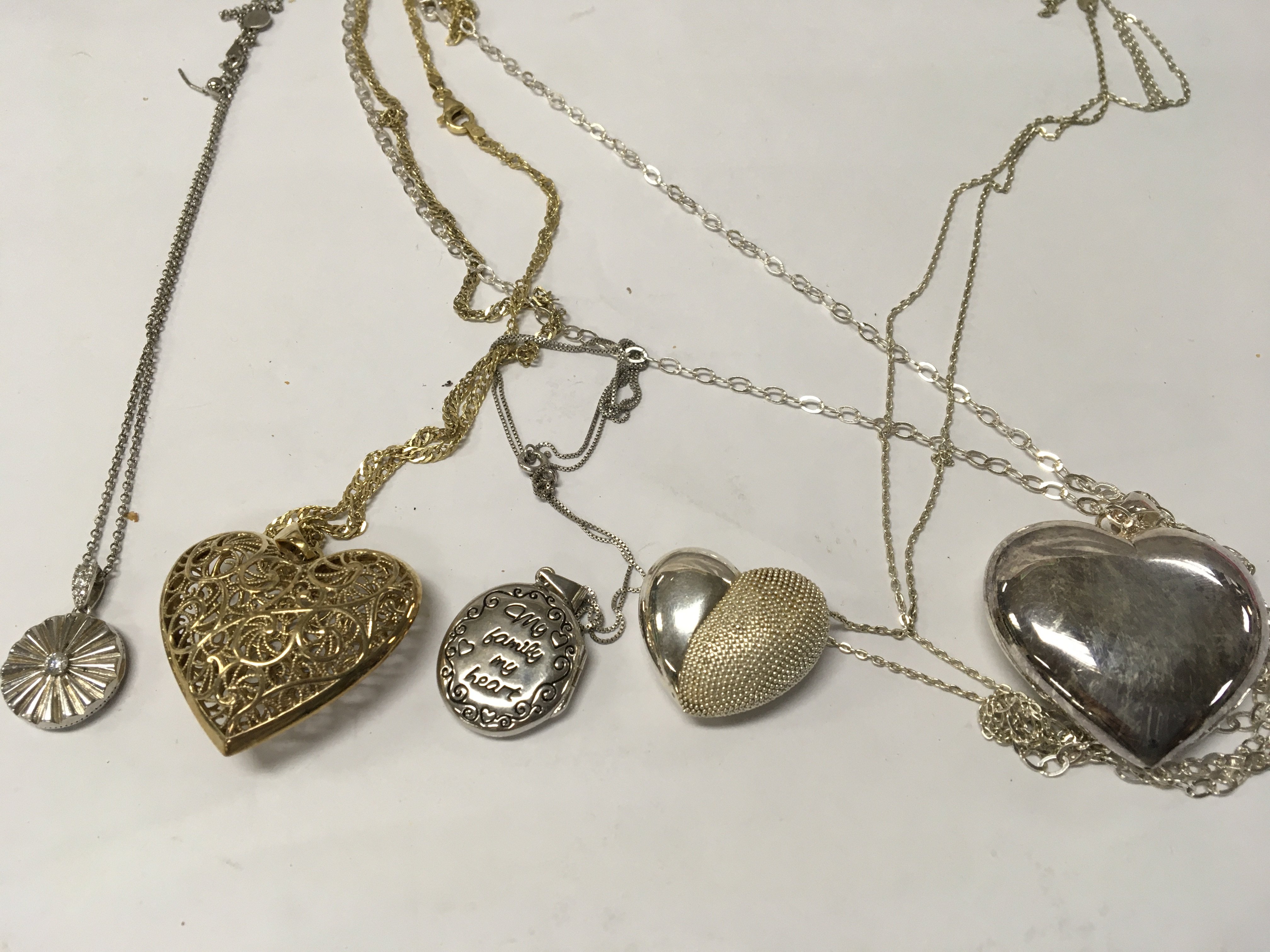 A collection of five silver pendant on chains .