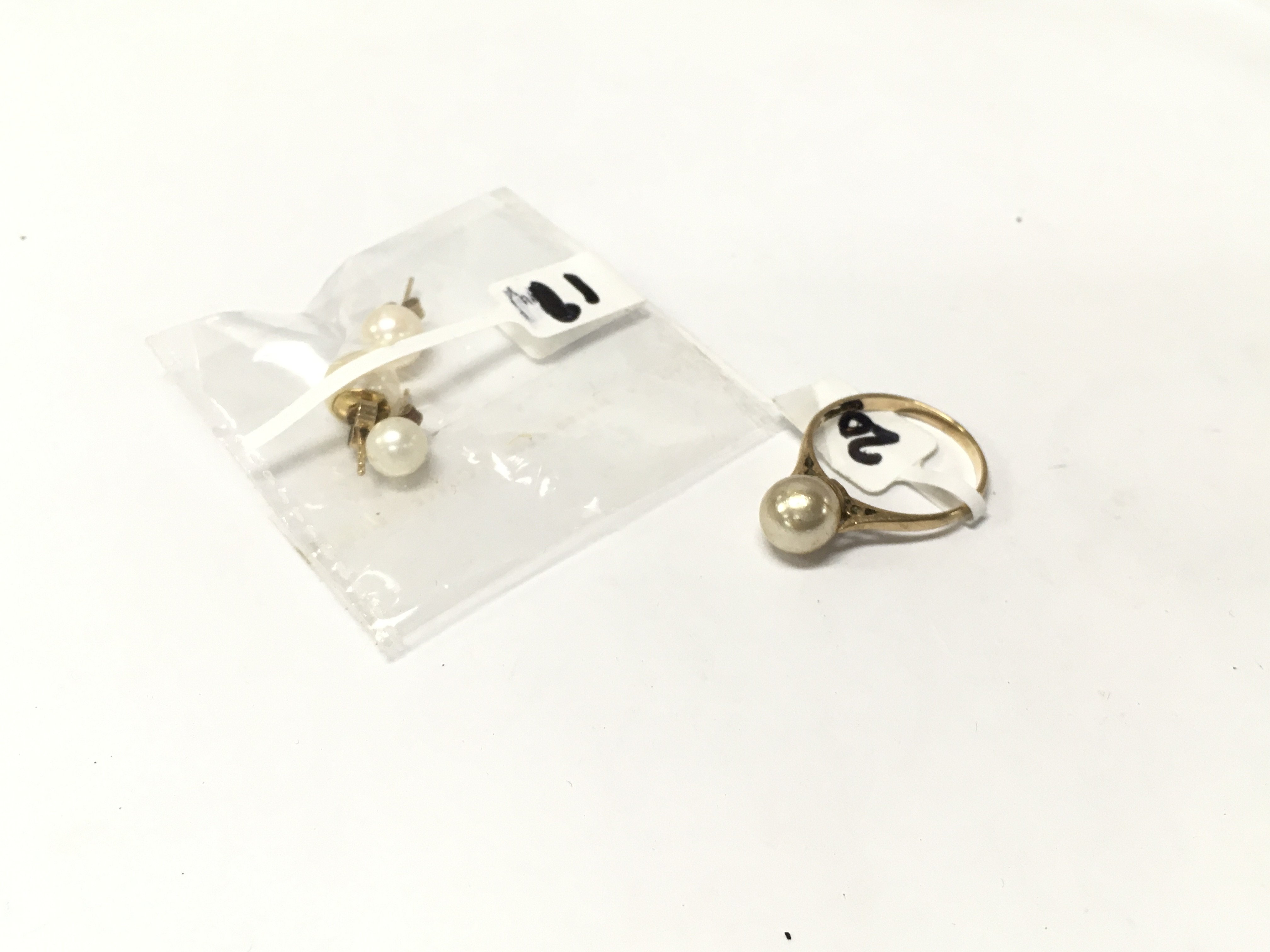 A 9ct gold pearl set of earrings and pearl solitaire ring.