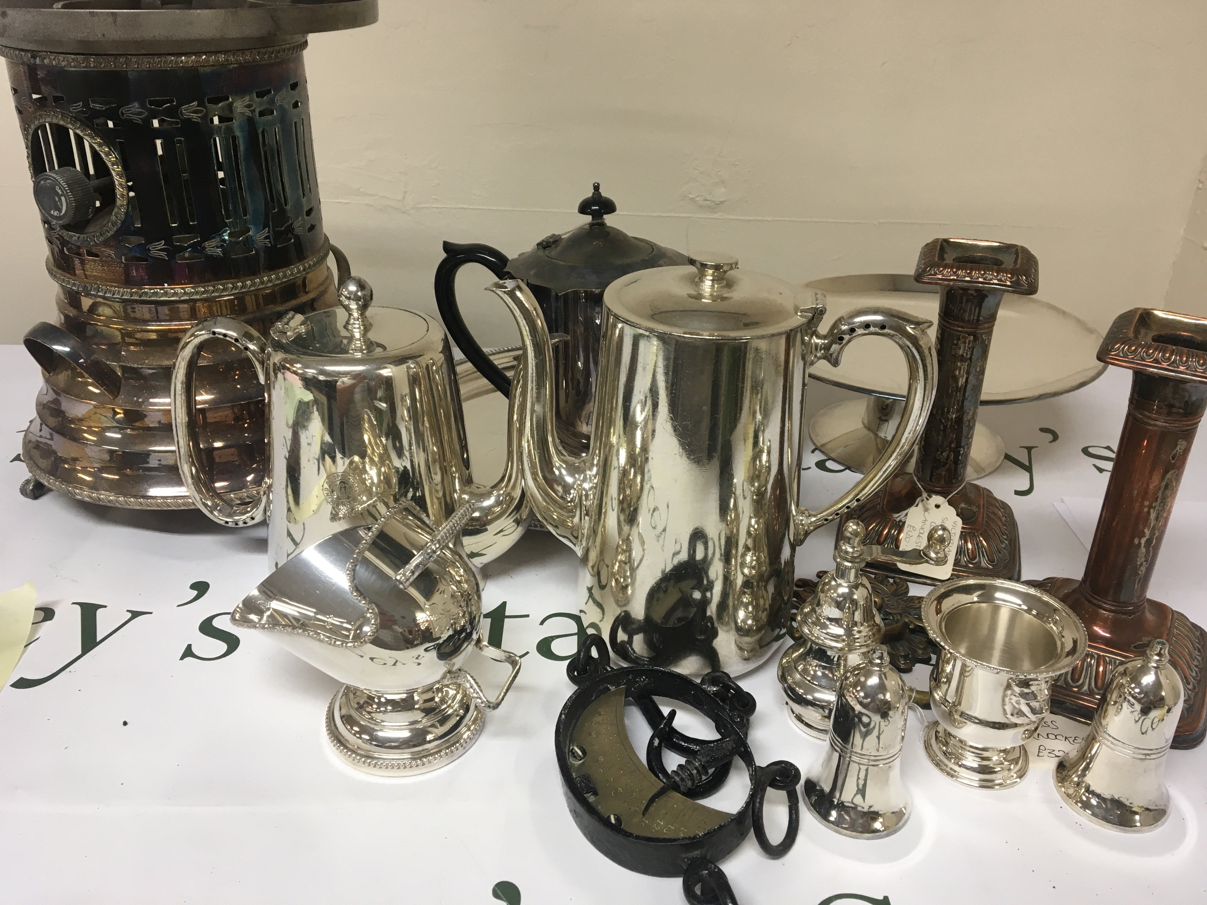 A box containing silver plate including a food warmer tea and coffee pots candle sticks and other ornaments including a vintage hanging scale