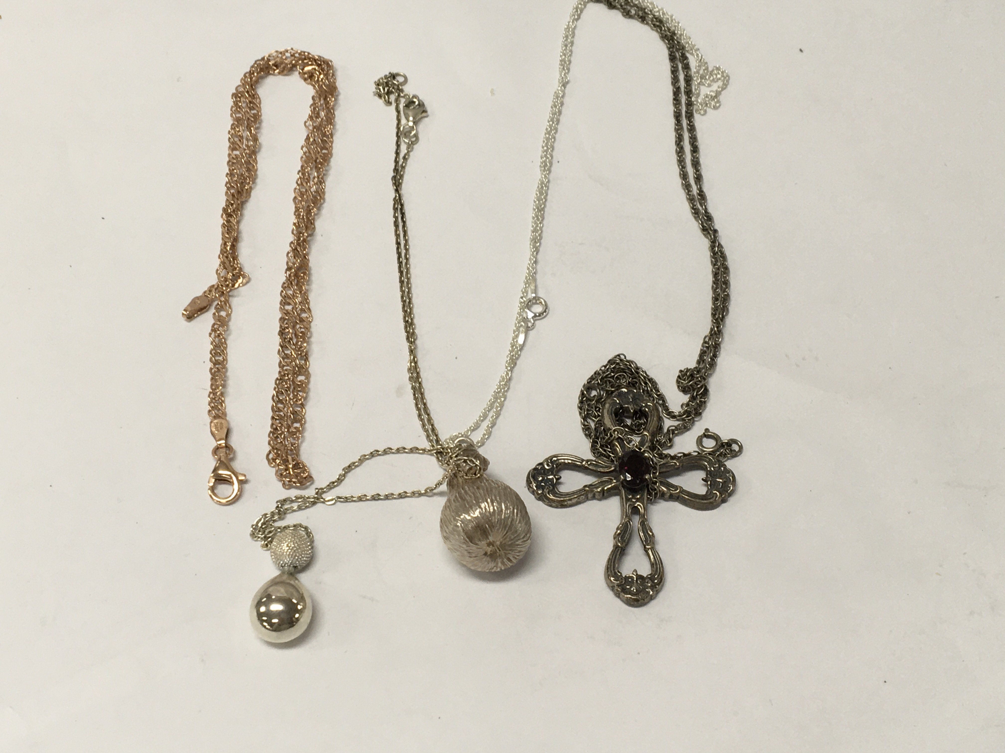 Three silver chains with attached pendants