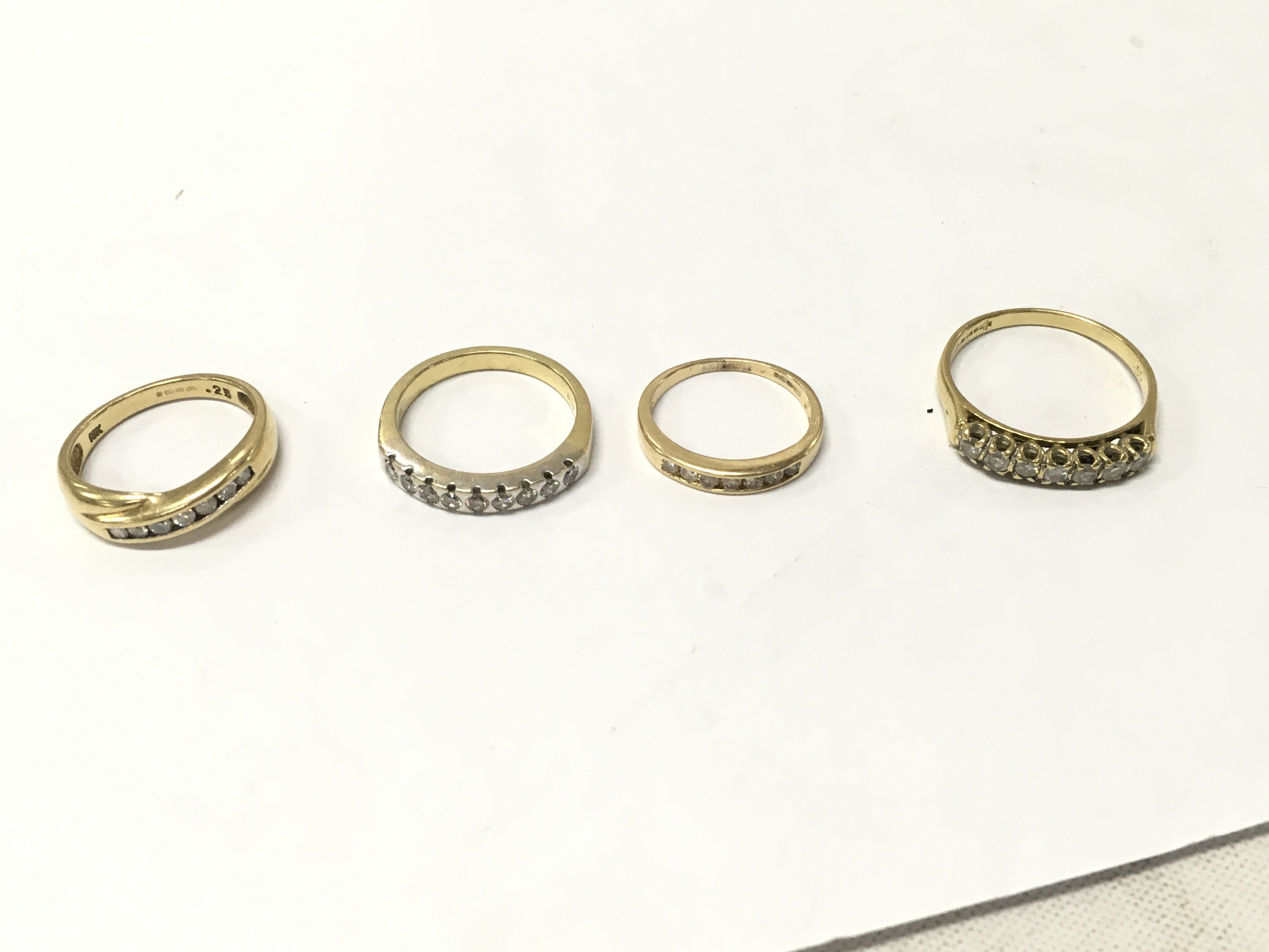 Four 18ct gold diamond row set rings, sizes J,N,O,S. approx weight 14grams.