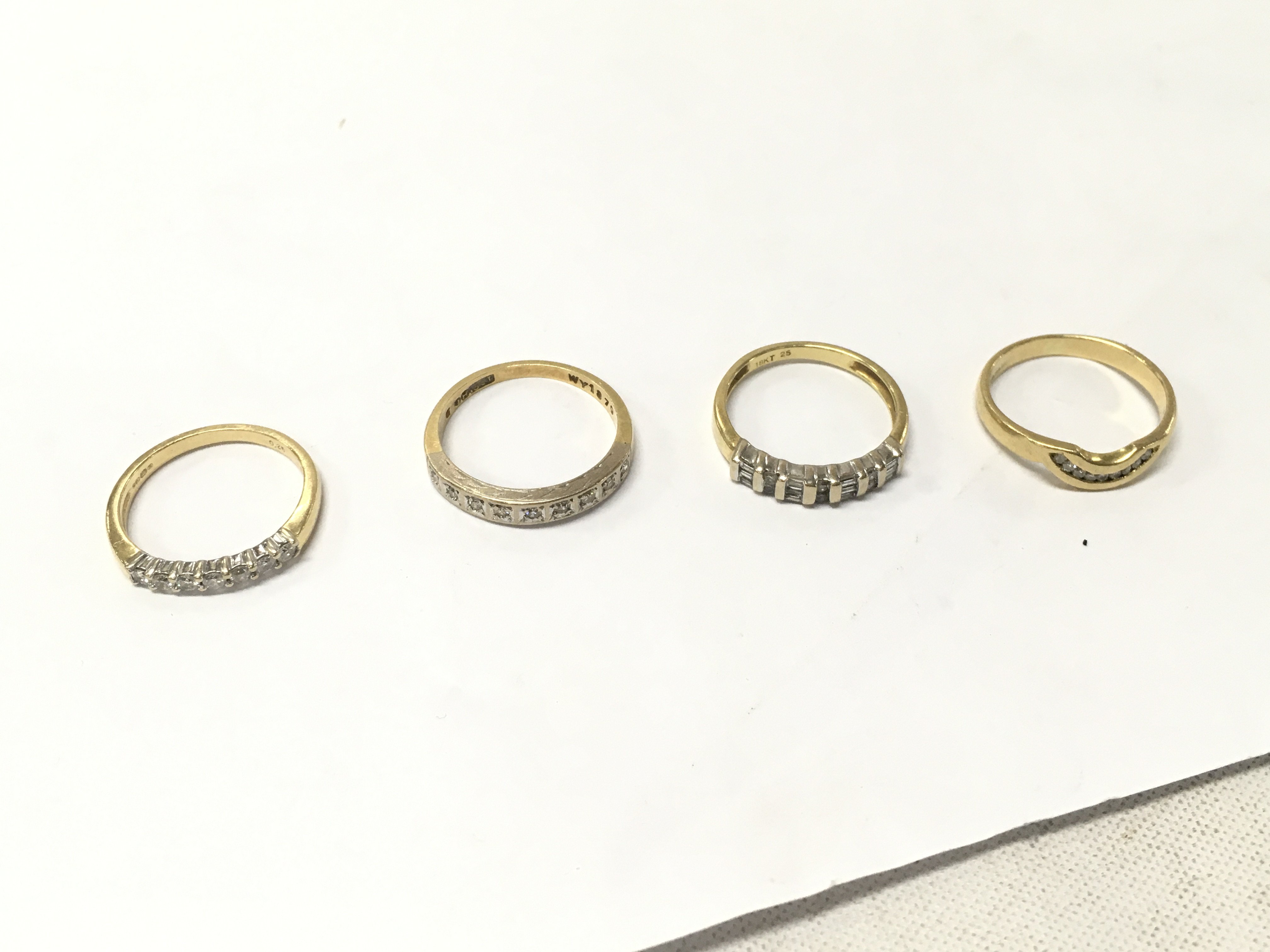 Four 18ct gold diamond row set rings, sizes L,N. Approx weight 10.8 grams.