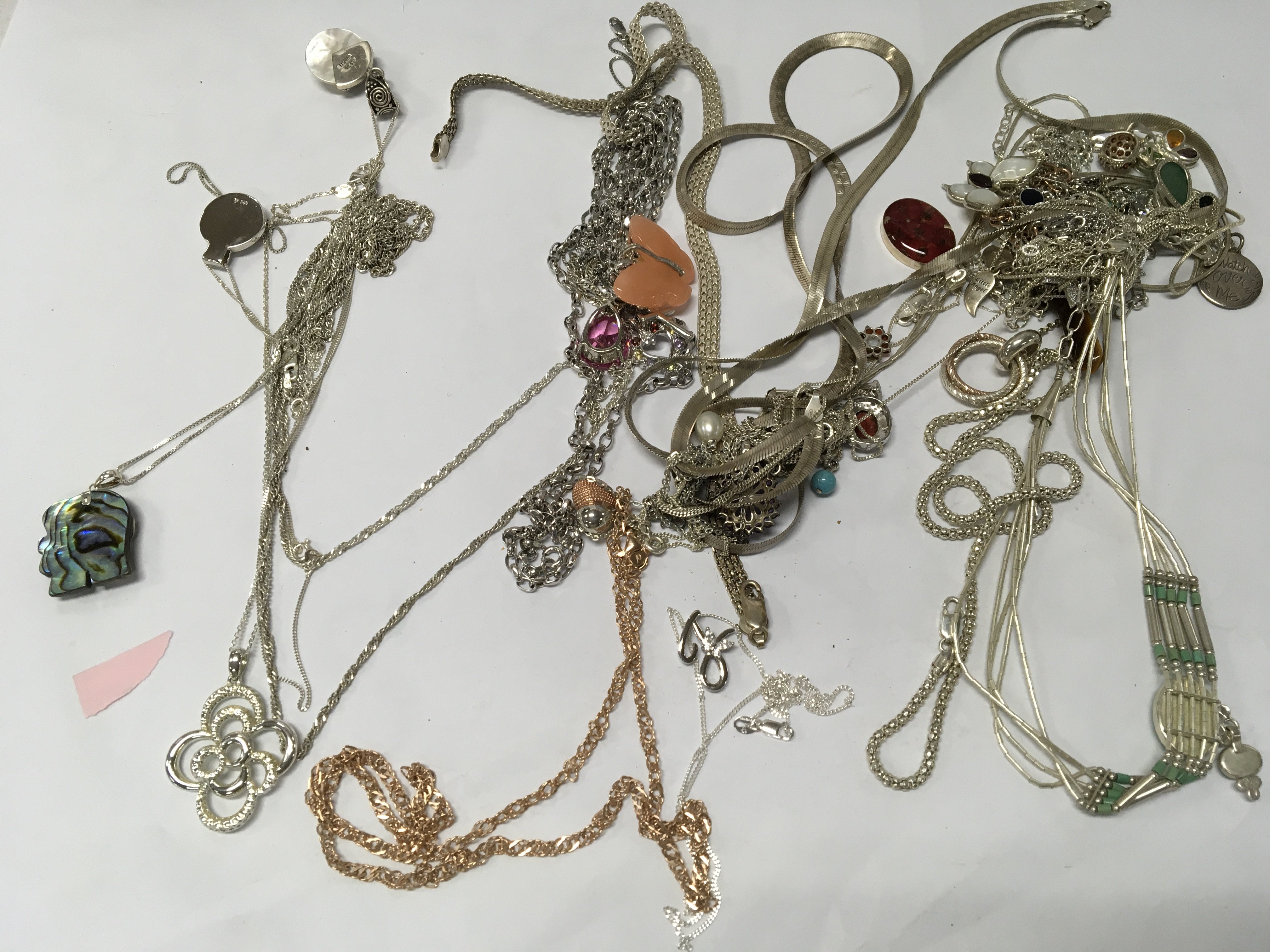 A collection of various silver chains and necklaces .