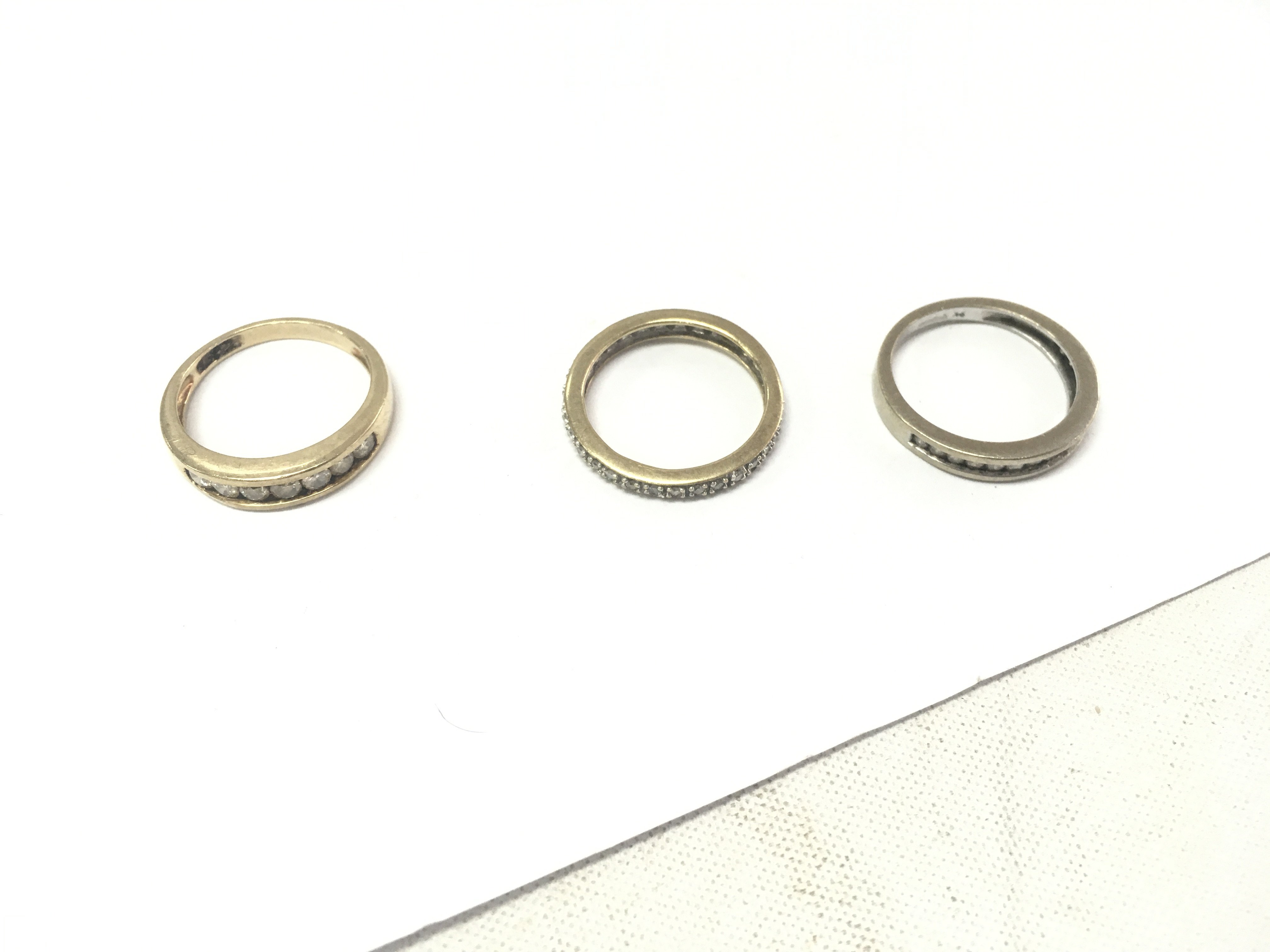 Three 9ct gold rings, two half eternity diamond rings and one full eternity ring. Approx weight 7.1 grams, size M1/2,N,O.