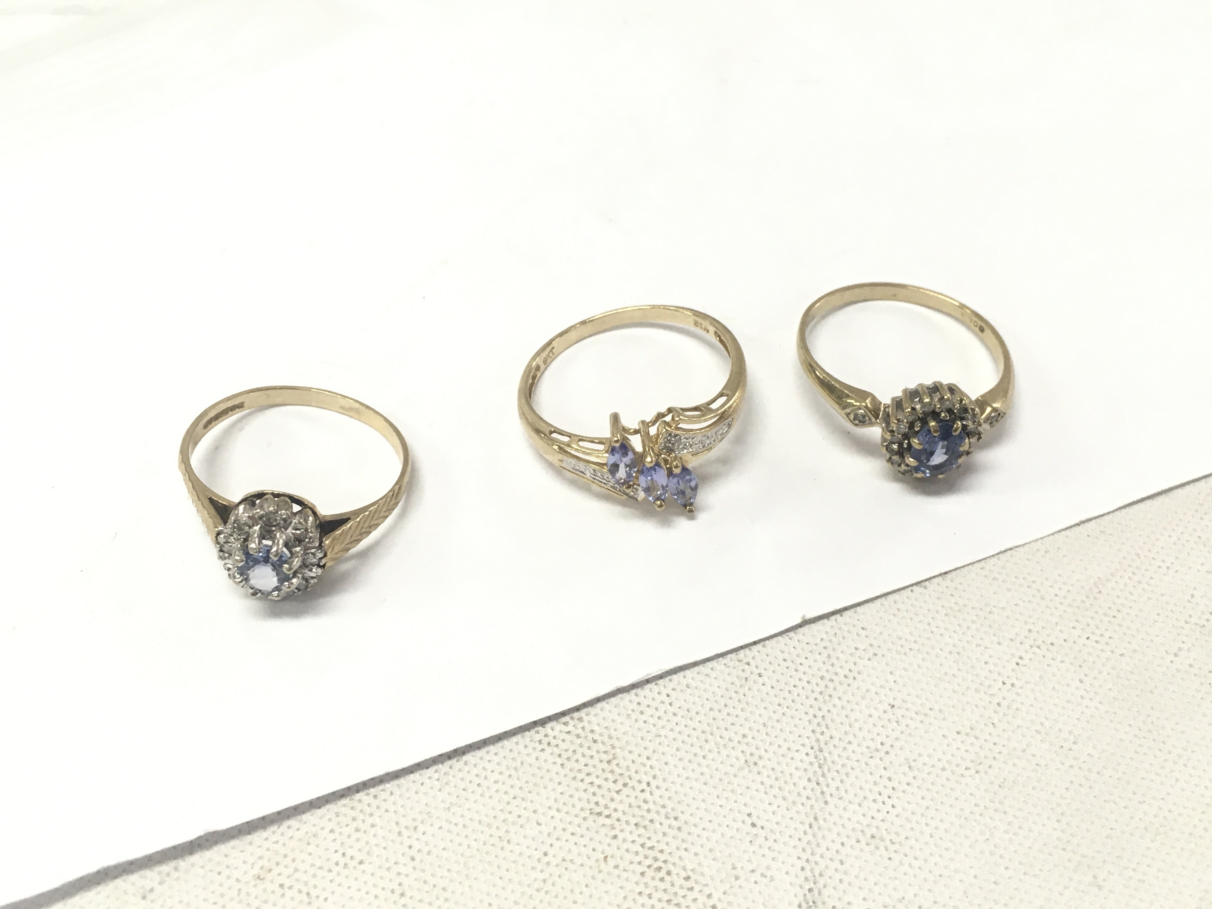 Three 9ct gold diamond and purple stone clusters. Approx weight 5.3 grams, size N,P.