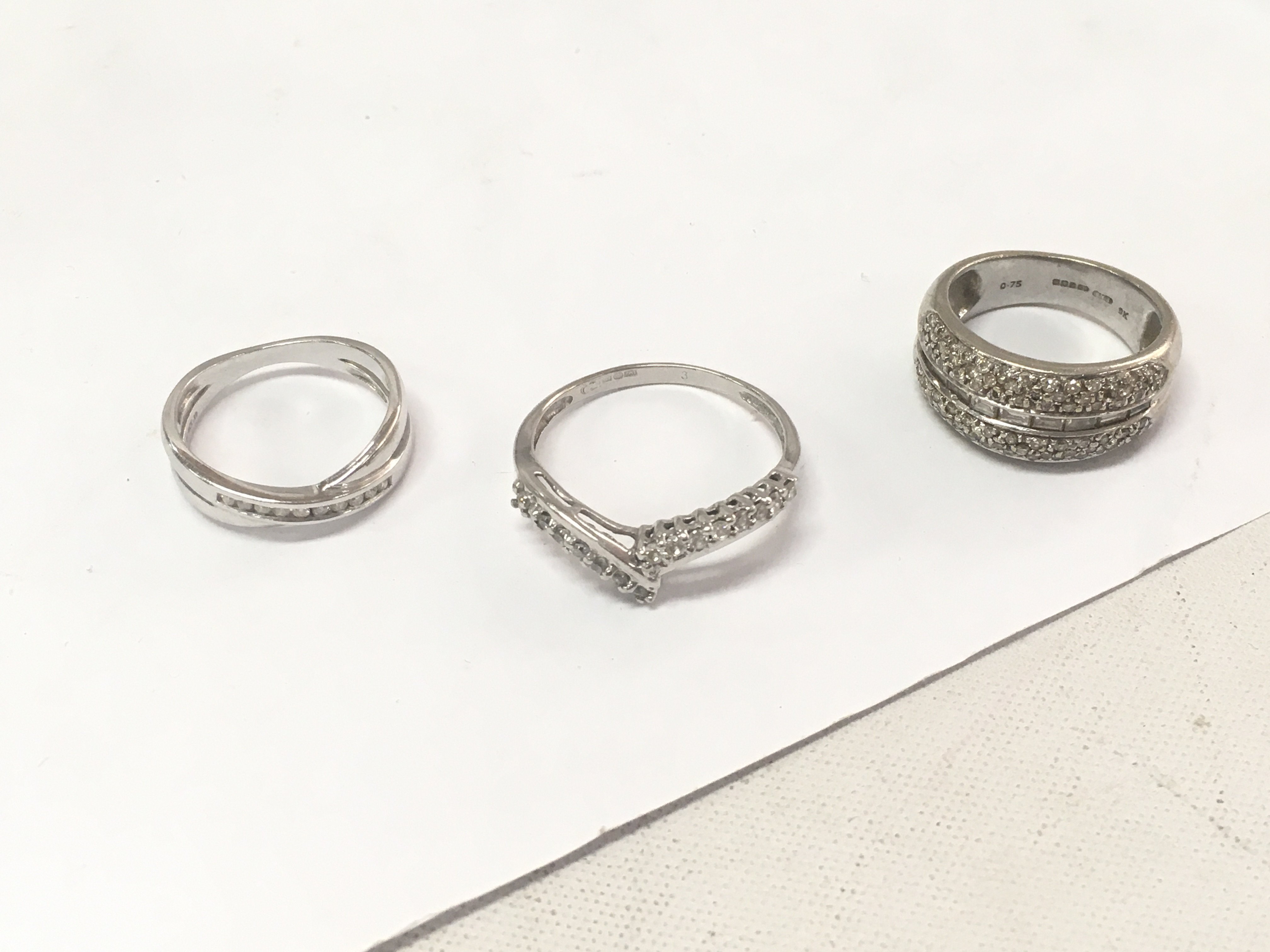 Three 9ct white gold diamond set bands. Size K,R. Approx weight 9.2 grams.