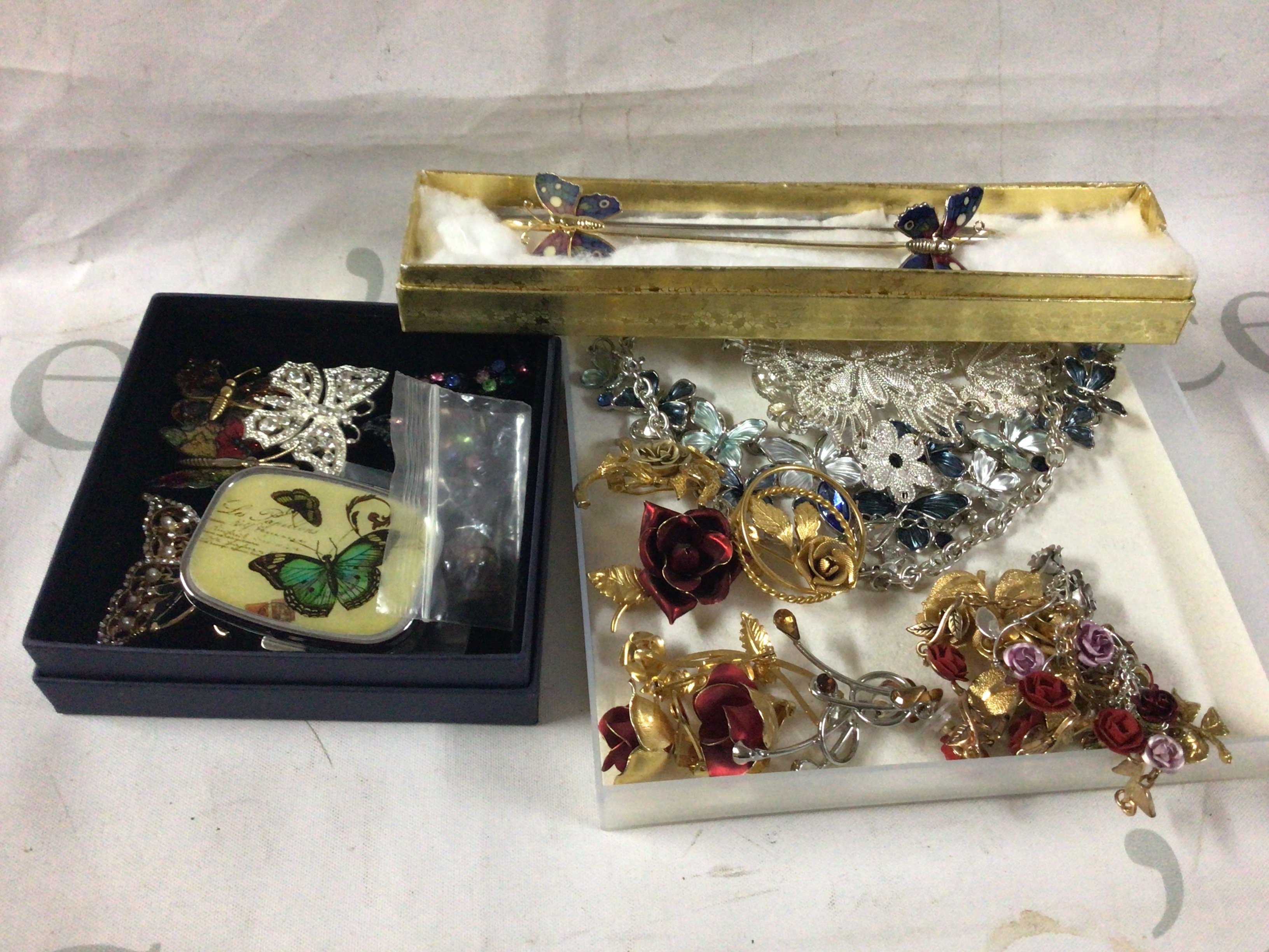 A collection of rose and butterfly costume jewellery.
