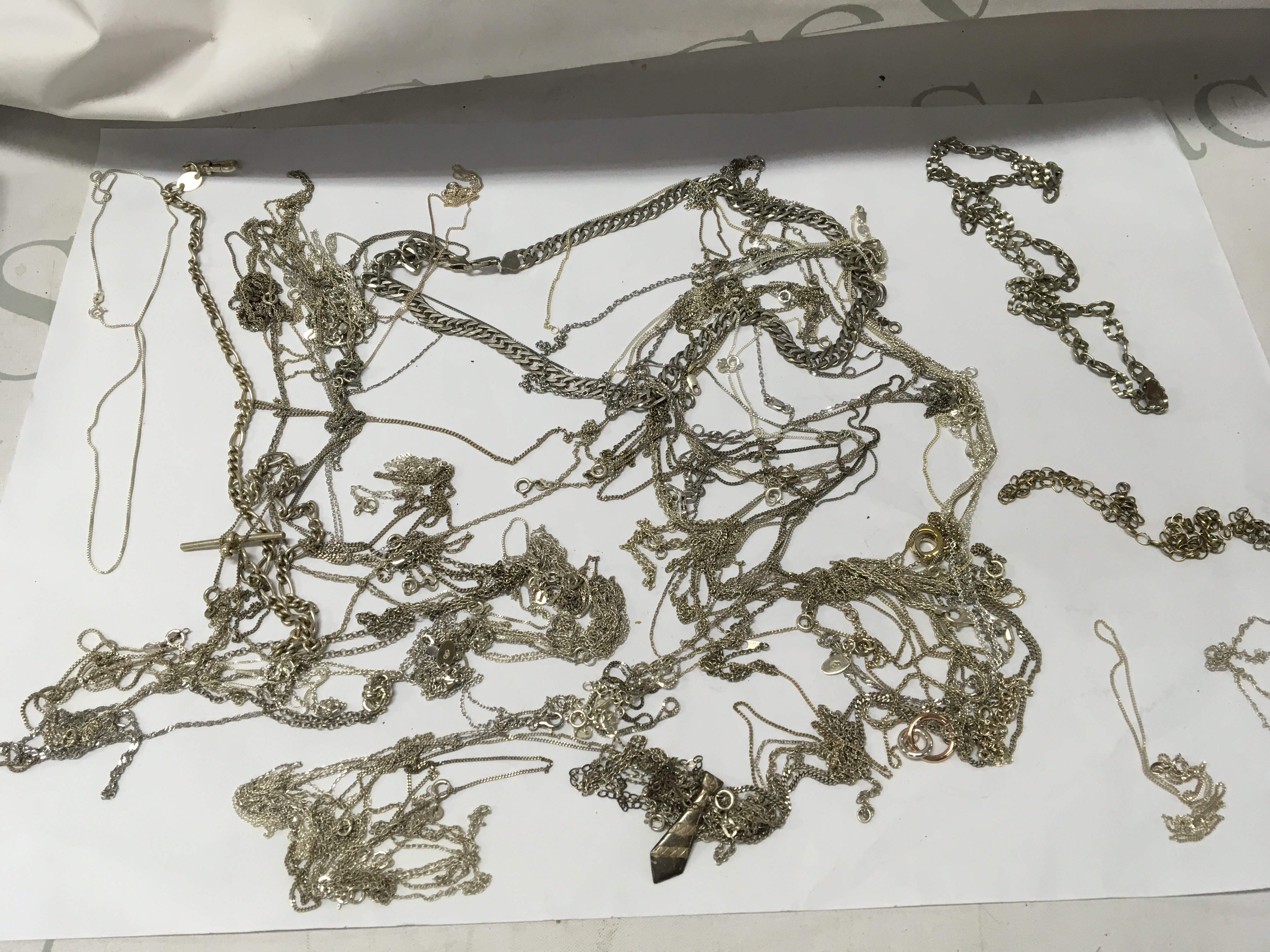 A collection of various silver necklaces .