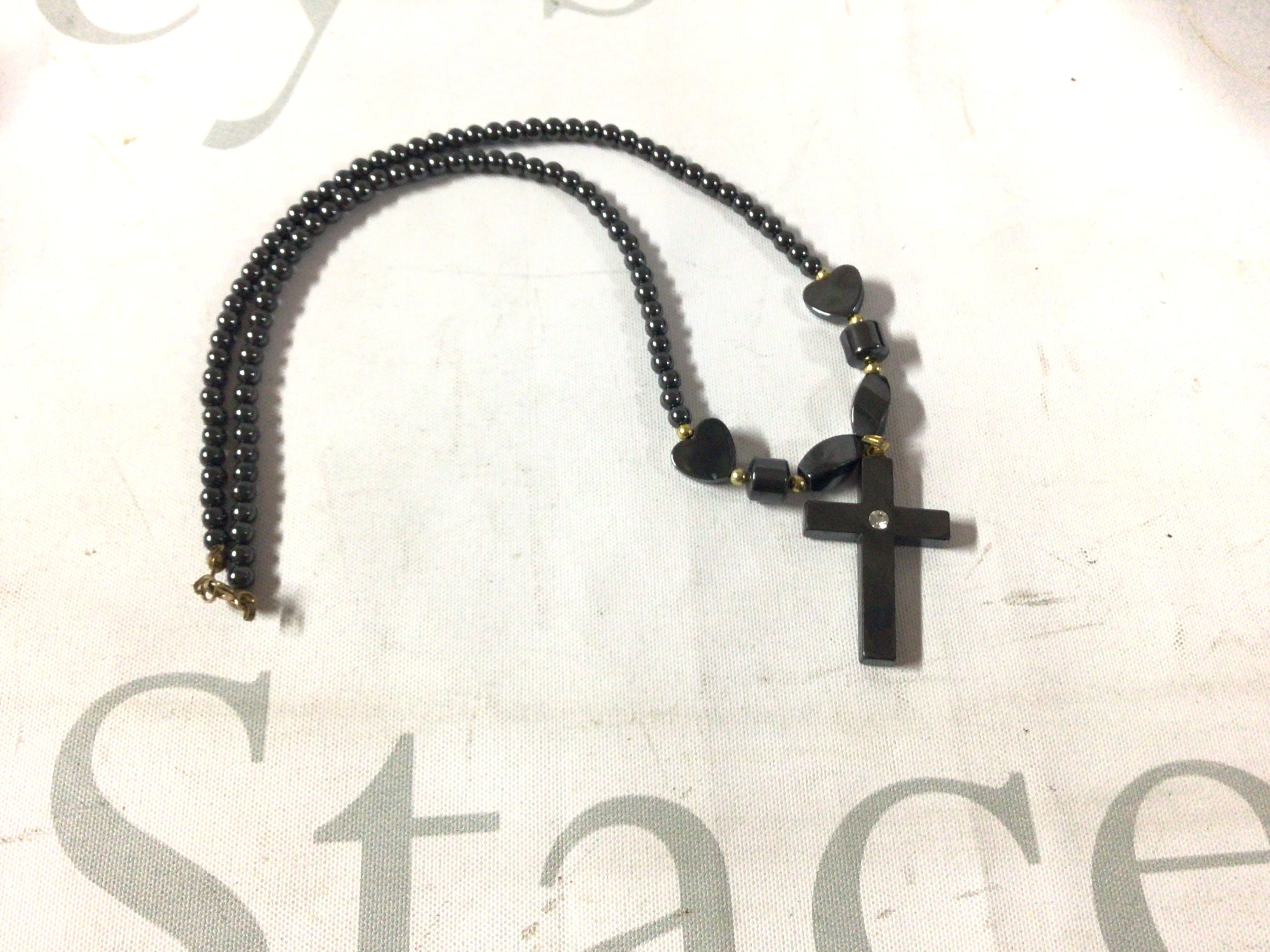 A hematite cross pendant and necklace with a 9ct gold clasp.