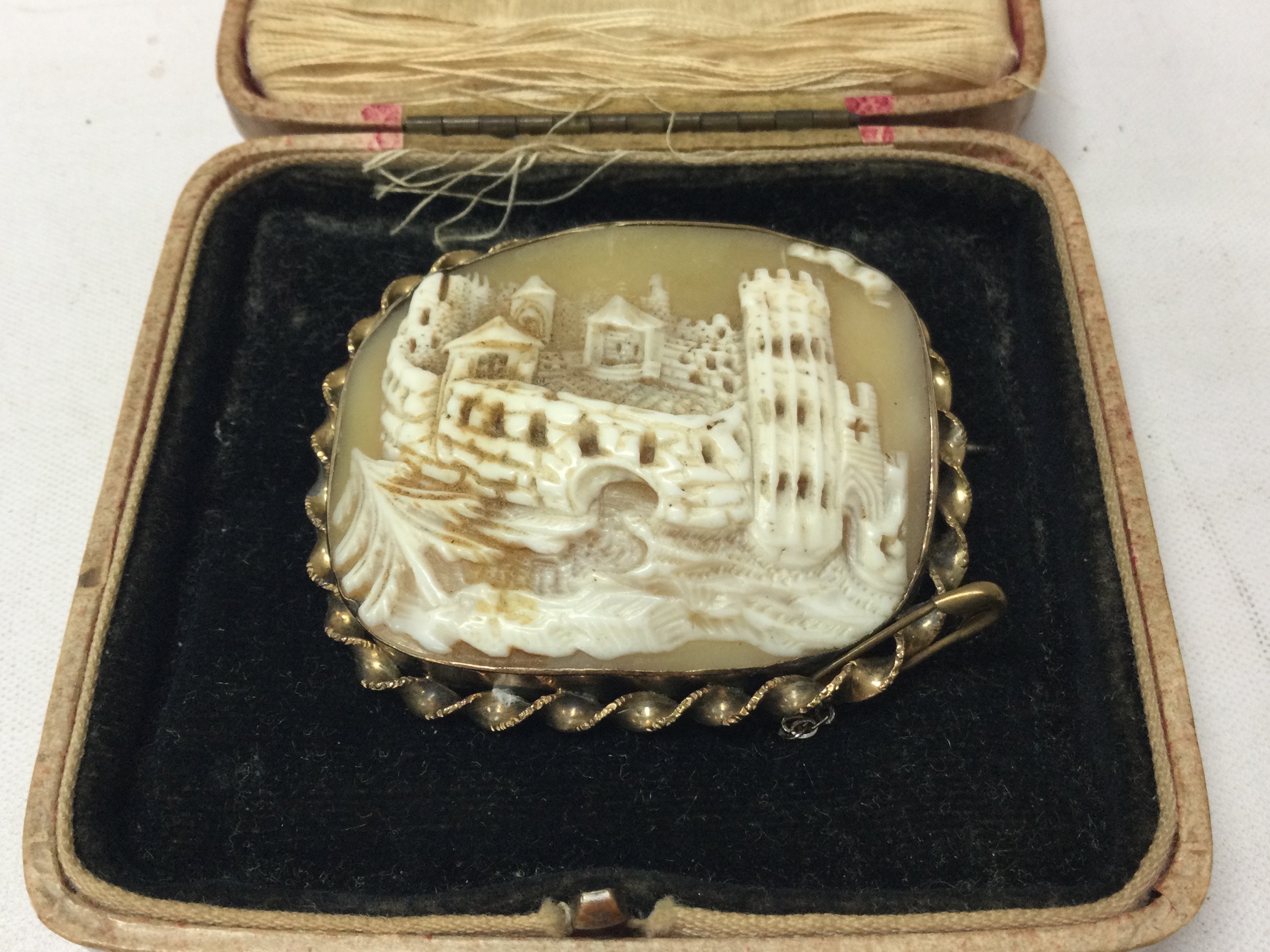 A carved cameo brooch of a historical castle monument. Postage category A