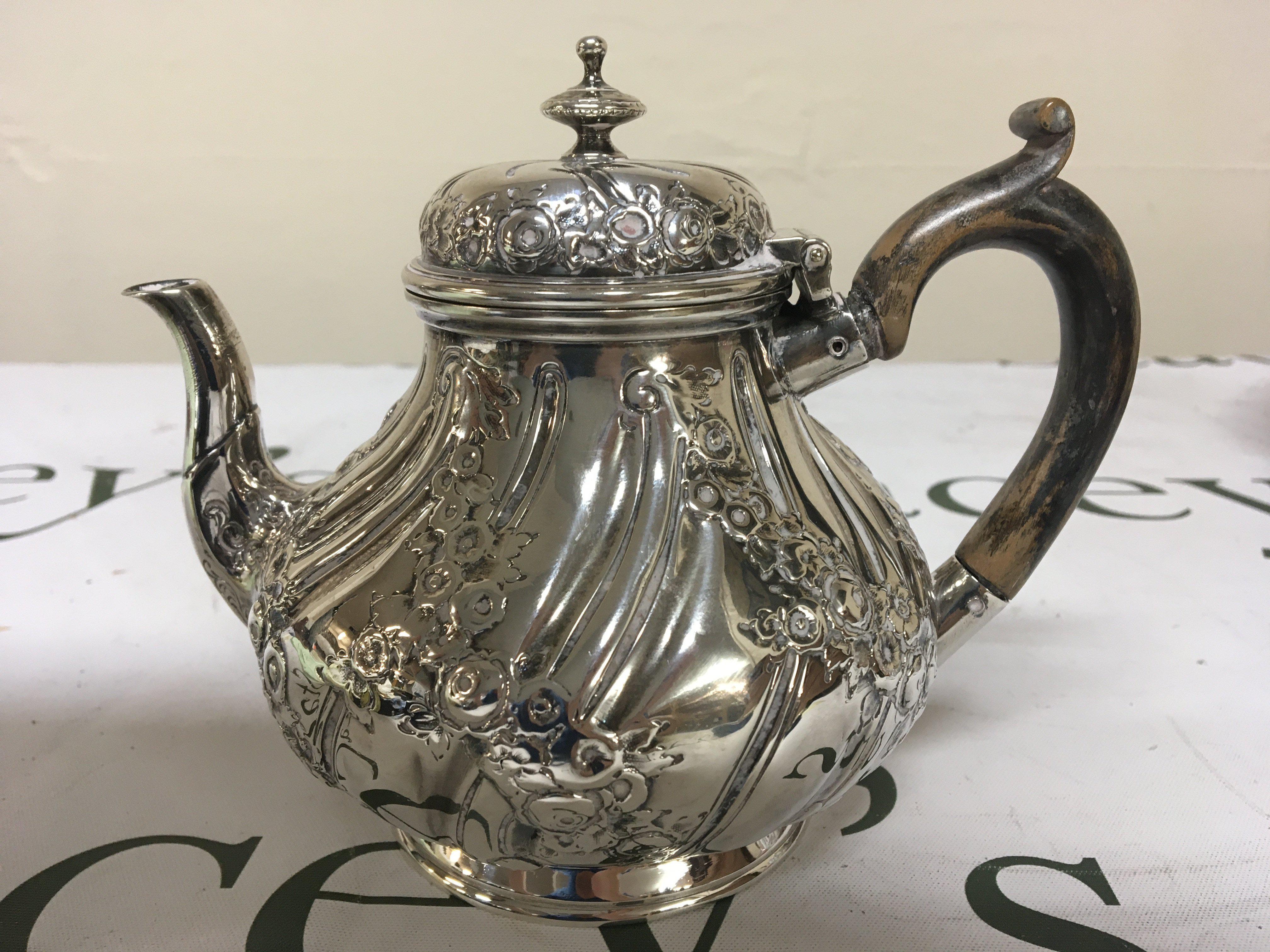 A Victorian silver tea pot with repousse chasing hinged lid marks to the base weight 378g
