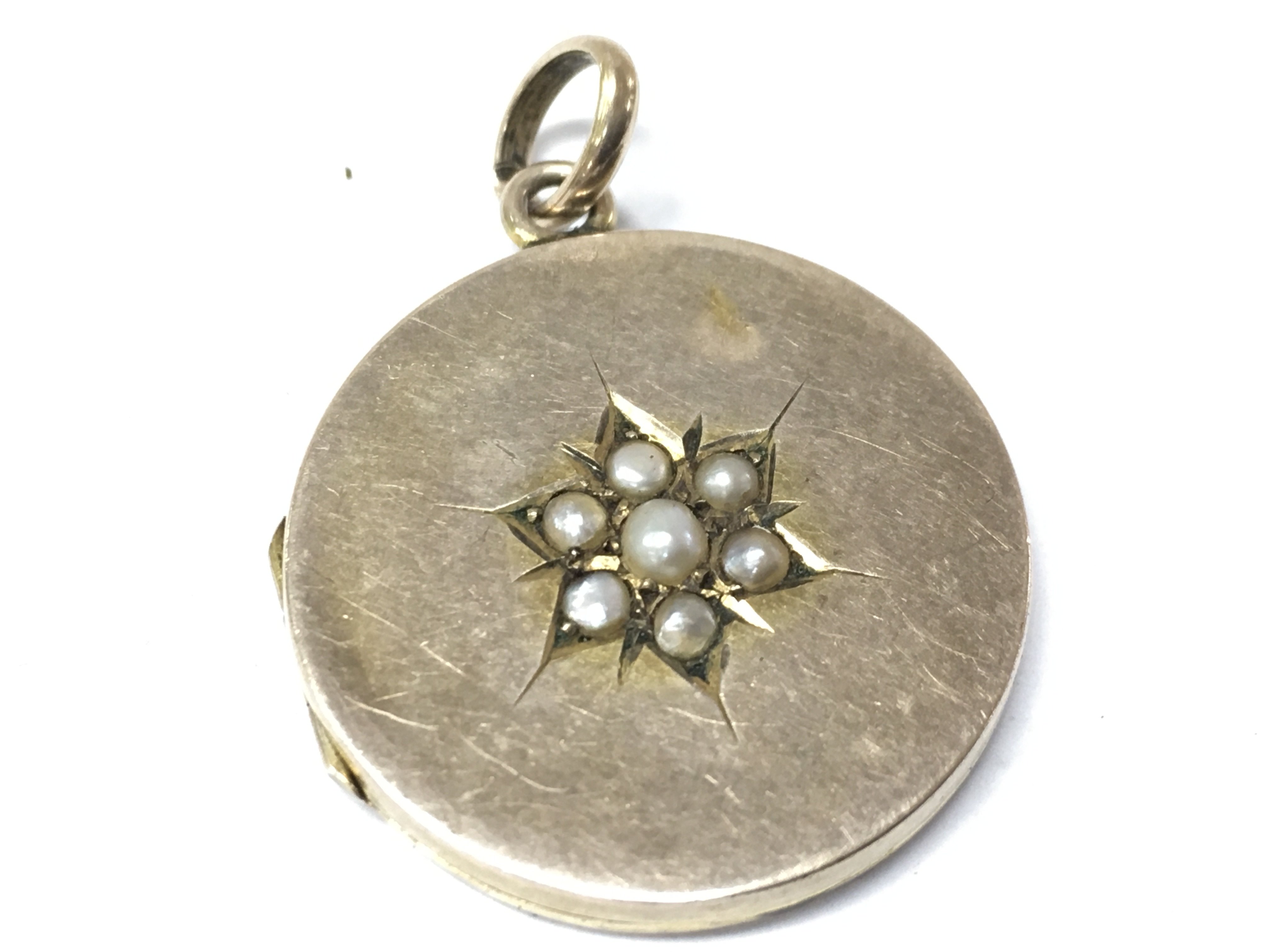 An unmarked gold locket set with pearls . 4.4g total weight. Postage category A
