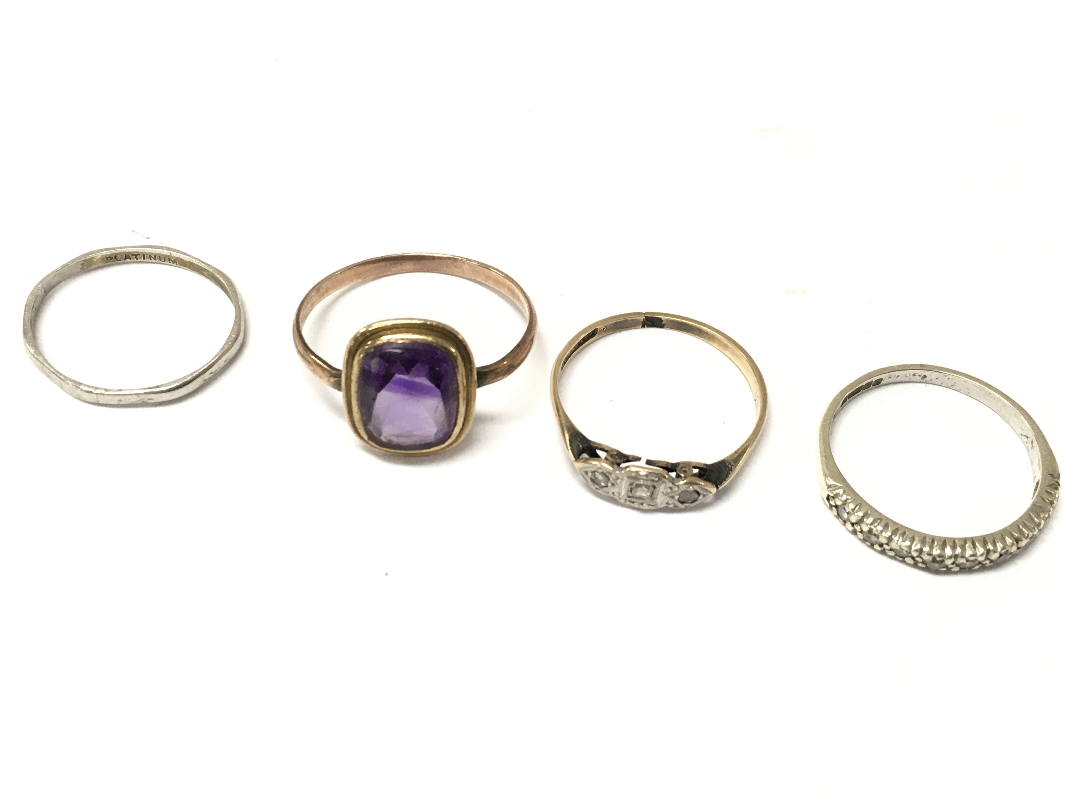 A Platinum ring (1.4g), unmarked ring set with purple gemstone, 9ct gold and platinum ring (1.1g), 9ct gold half eternity ring (1.1g)Postage category A