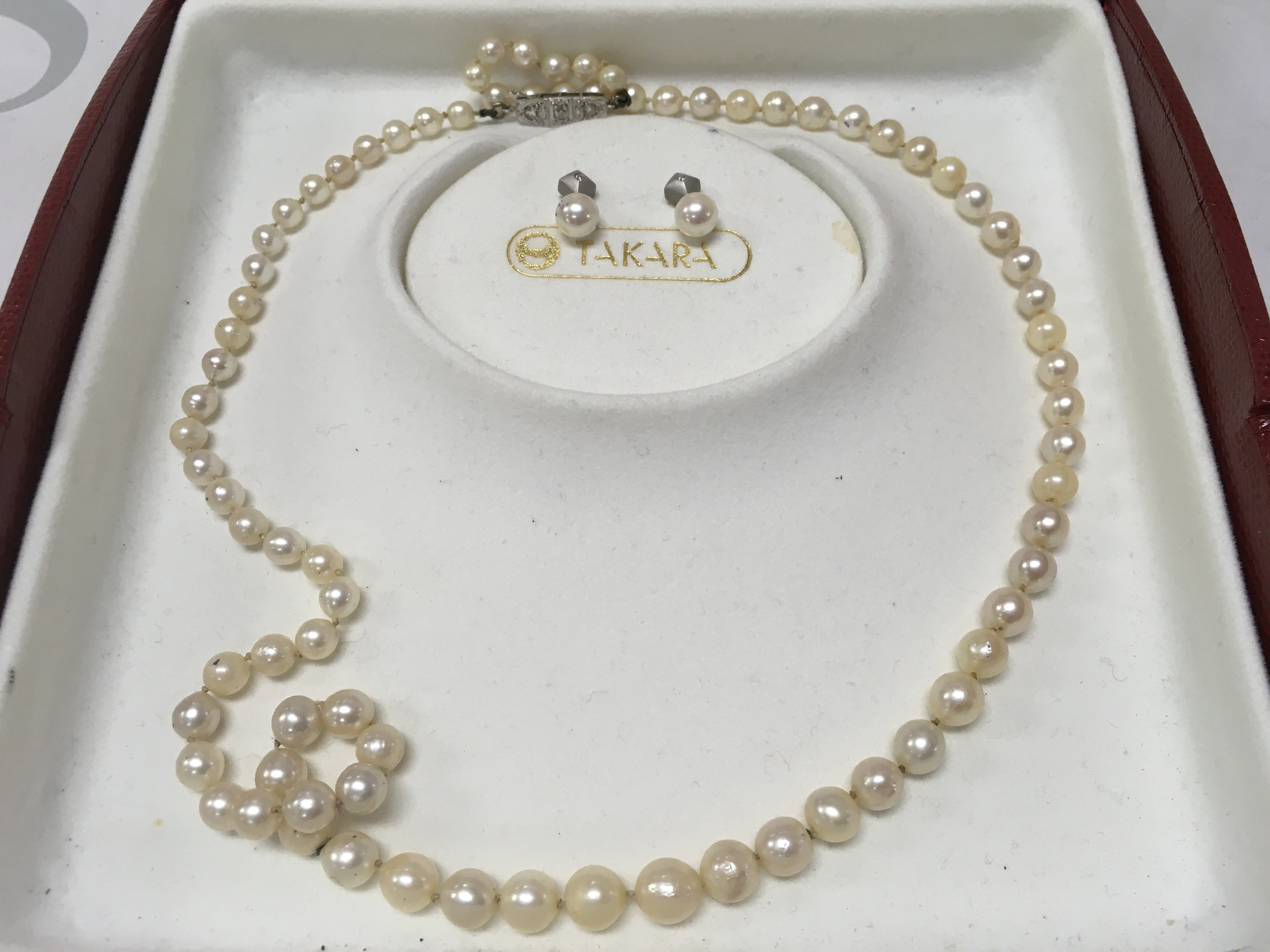 A Takara pearl necklace set with 18 carat diamond set clasp and matching earrings , postage category B