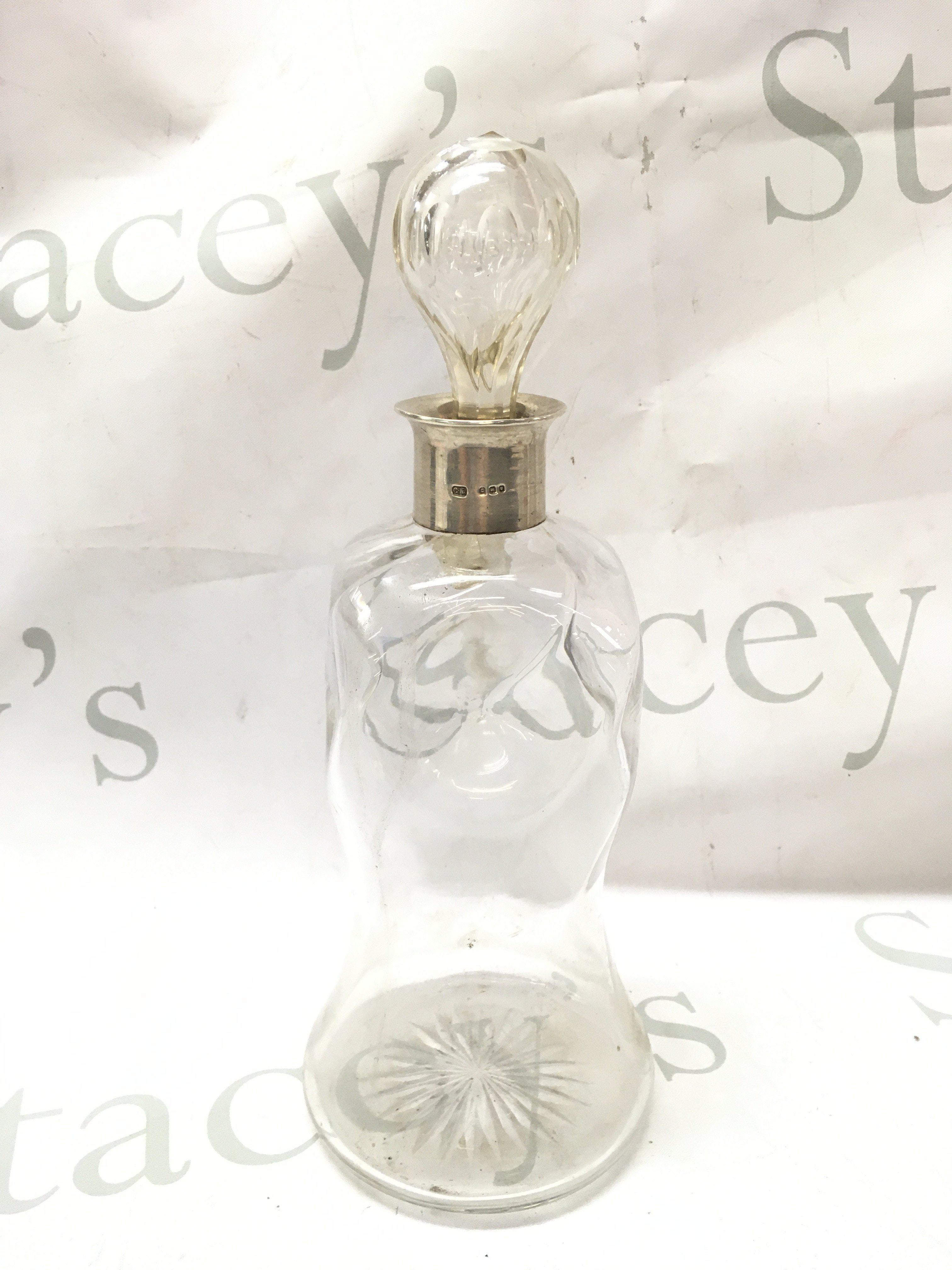 A vintage glass decanter with a hallmarked silver rim , 28.5cm tall. This lot cannot be posted