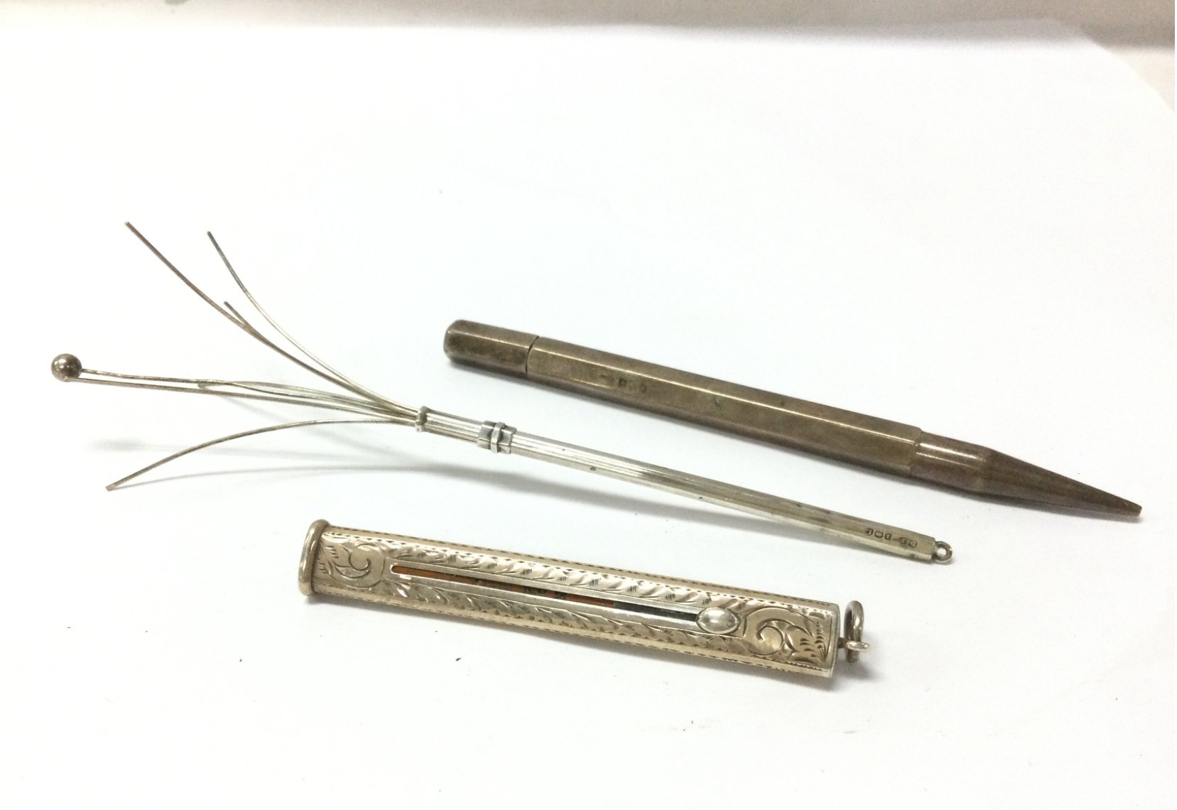 Two silver pencils and a silver swizzle stick. Postage category A
