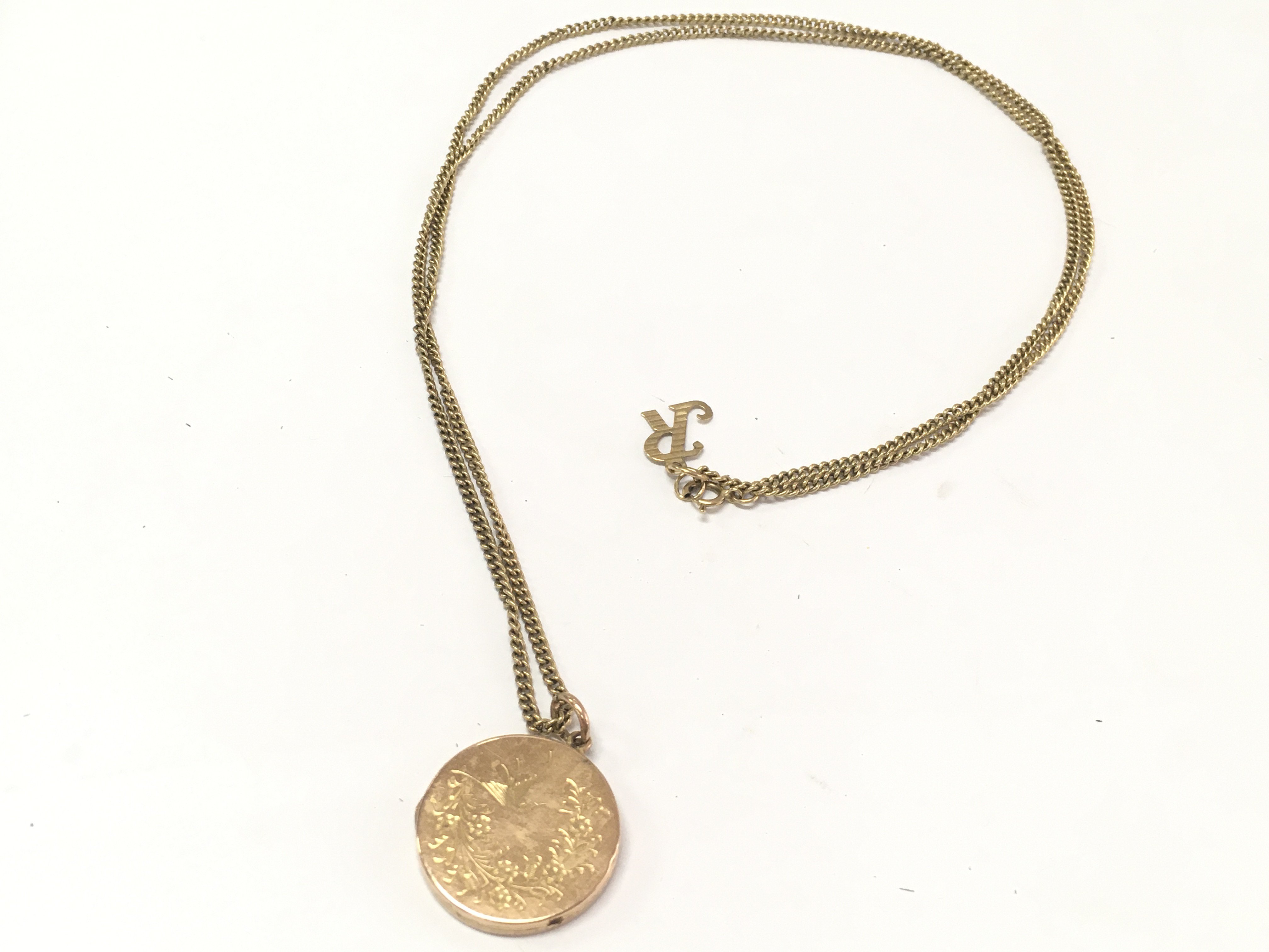 A 9ct gold locket and chain . 10g total weight. Postage category a