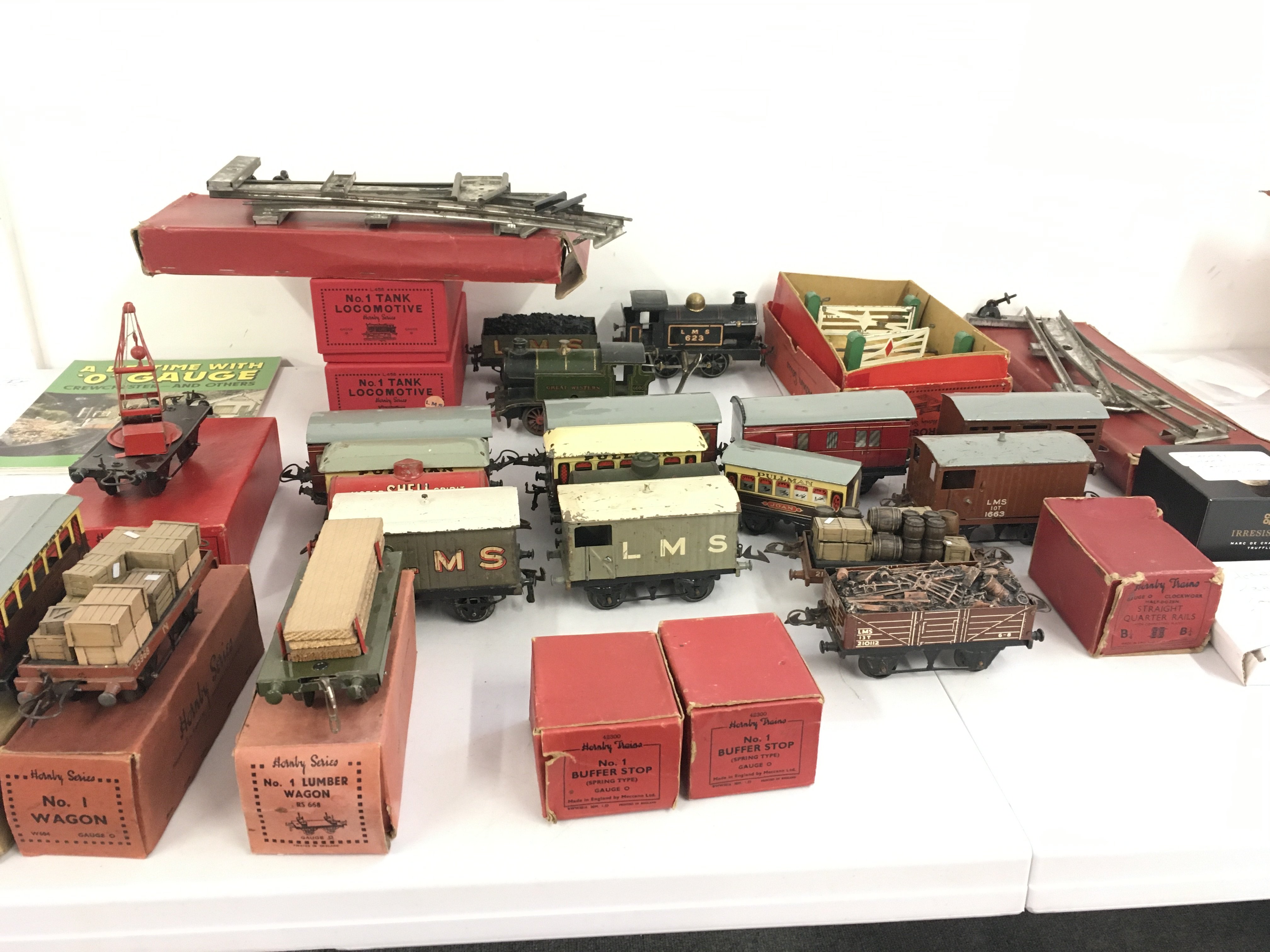 A collection of clockwork tinplate railway locos with numerous wagons and coaches plus some track and accompanied. 0 gauge. No reserve (2)
