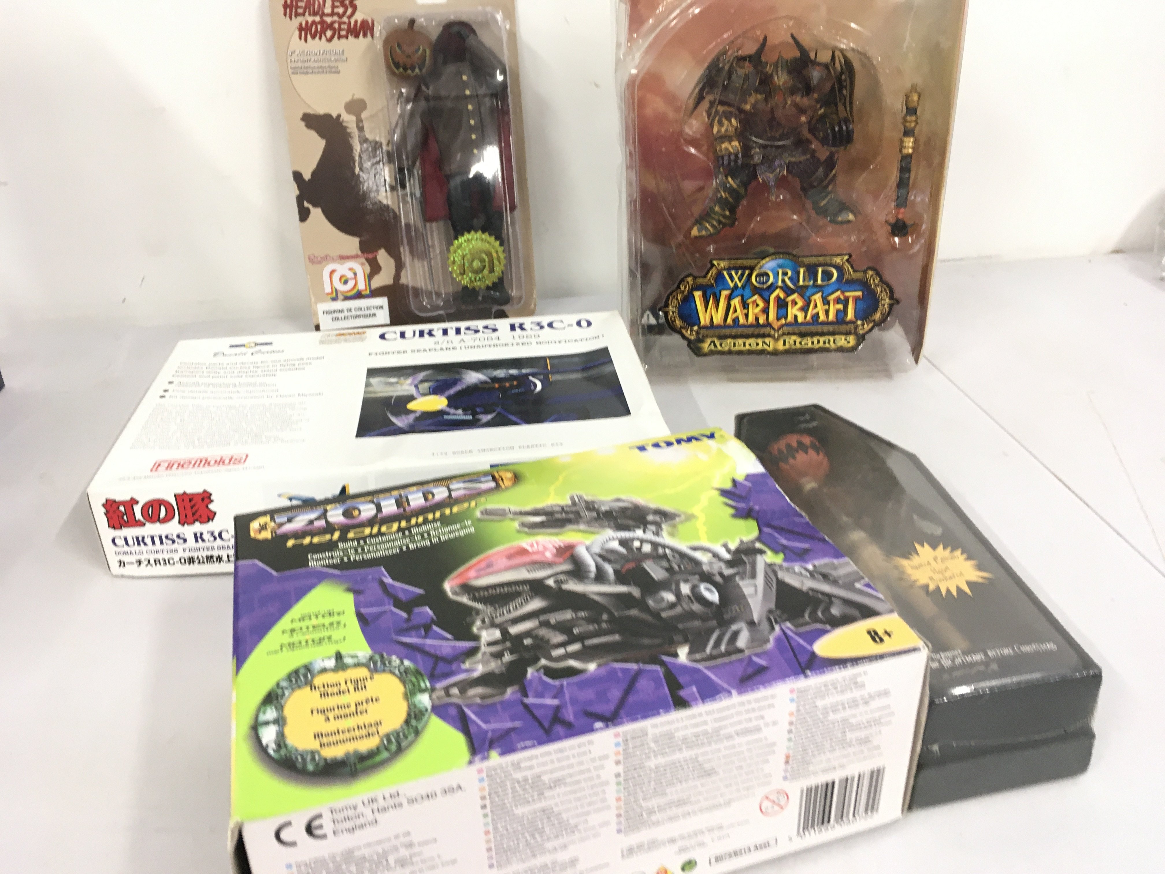 A collection of 5 boxed toys featuring Zoids Hel Digunner&hellip;Curtis R3C.0 model aircraft kit&hellip;carded Headless Horseman 8 inch action figure&hellip;World of Warcraft Thargas Anvilmar&hellip;Pumpkin Jack Porcelain doll from Nightmare before Christmas. No reserve