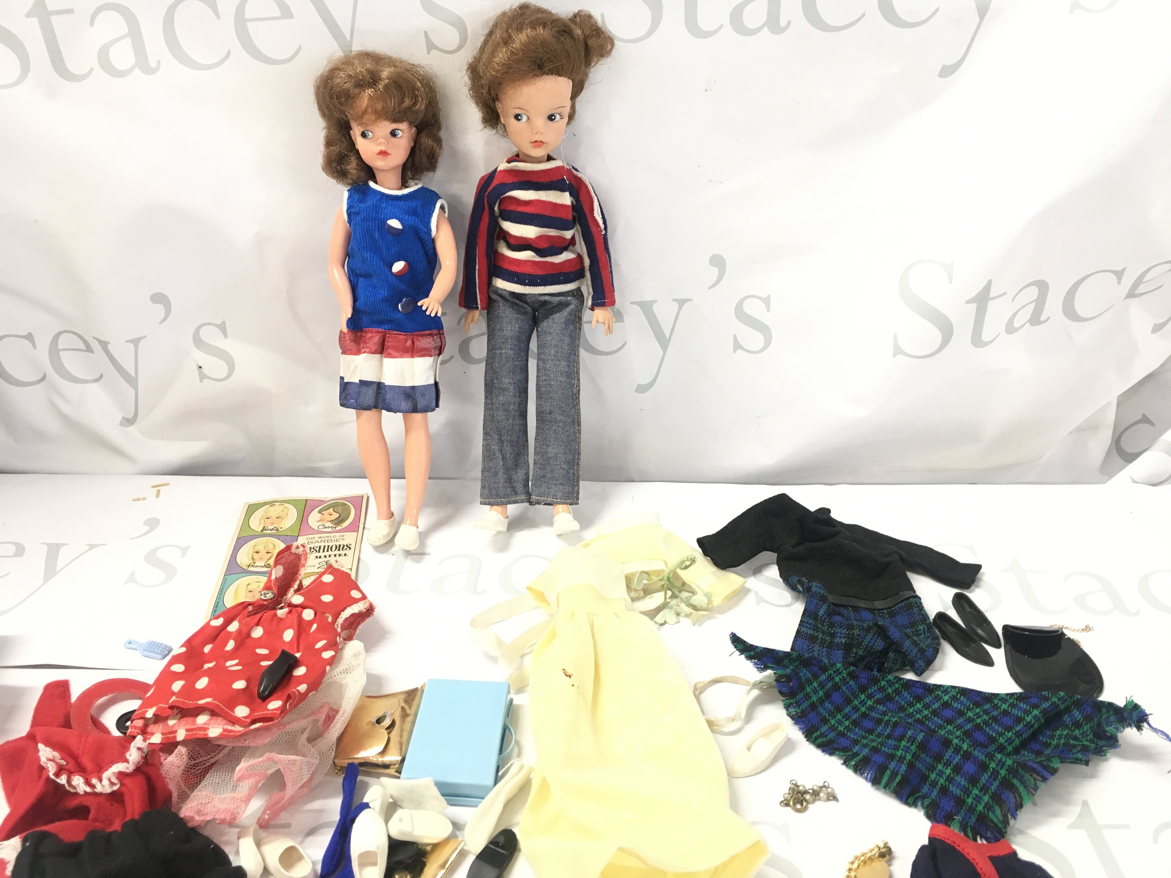 A Bag Containing 2 Vintage Sindy Dolls And A Collection Of Clothes.