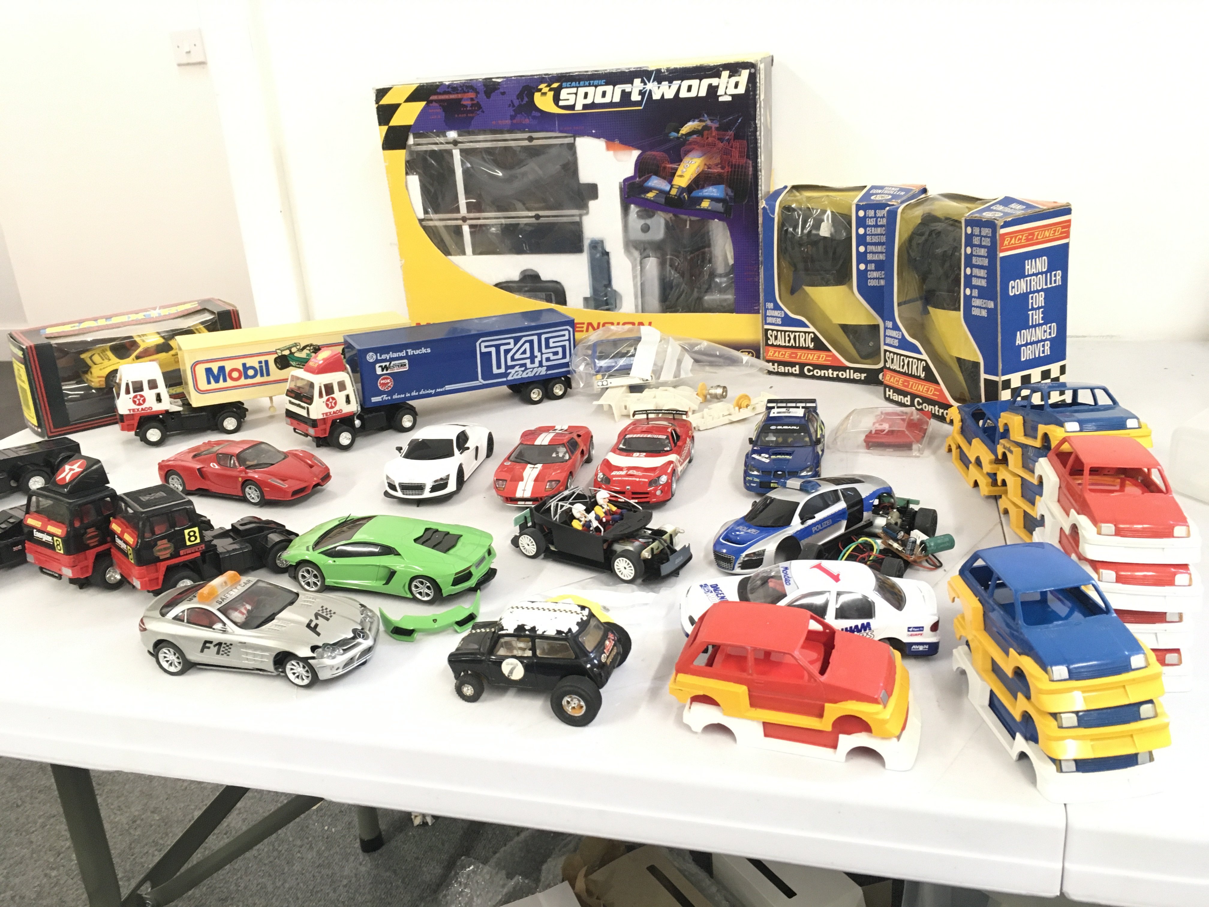 A collection of Scalextric ..Hornby cars and lorries. Includes accessories and boxed Sportsworld multi-lane extension kit. No reserve