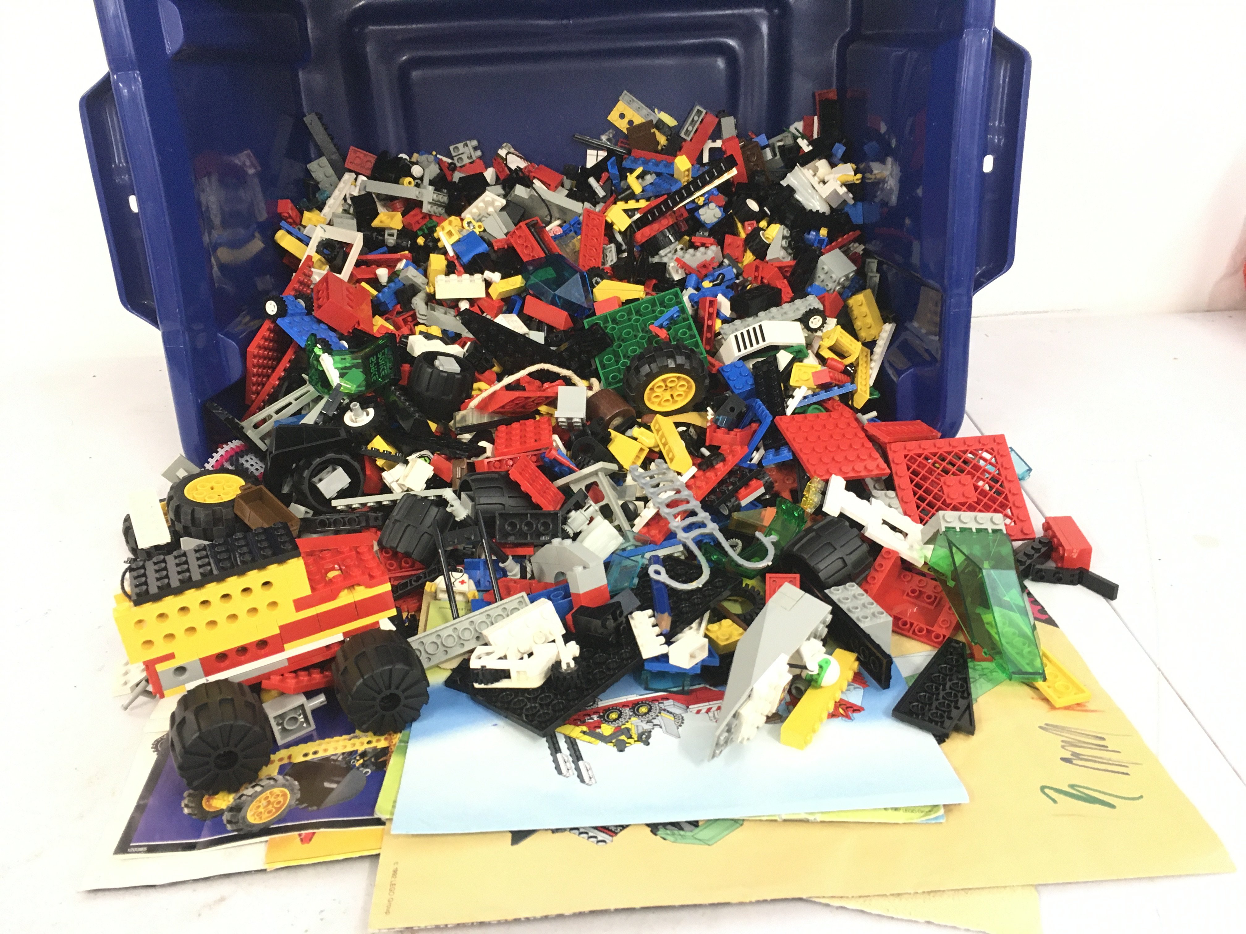A box containing a large quantity of loose Lego building blocks and accessories. Also includes some leaflet but not necessarily matched to contents. No reserve