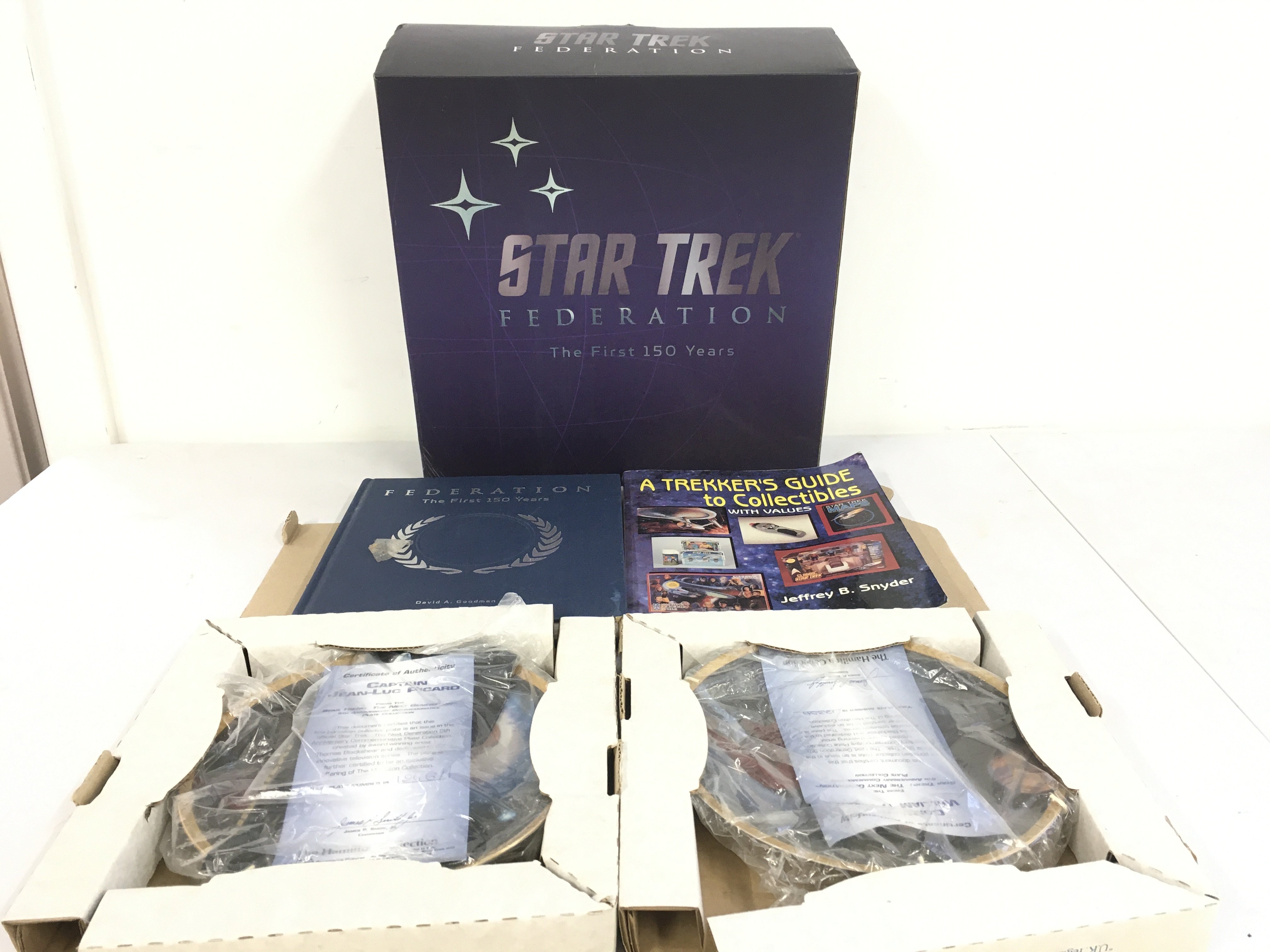 A collection of Star Trek pieces including two boxed Hamilton plates and a boxed Federation the first 150 years with book. Plus Trekkers Guide to Collectibles. No reserve