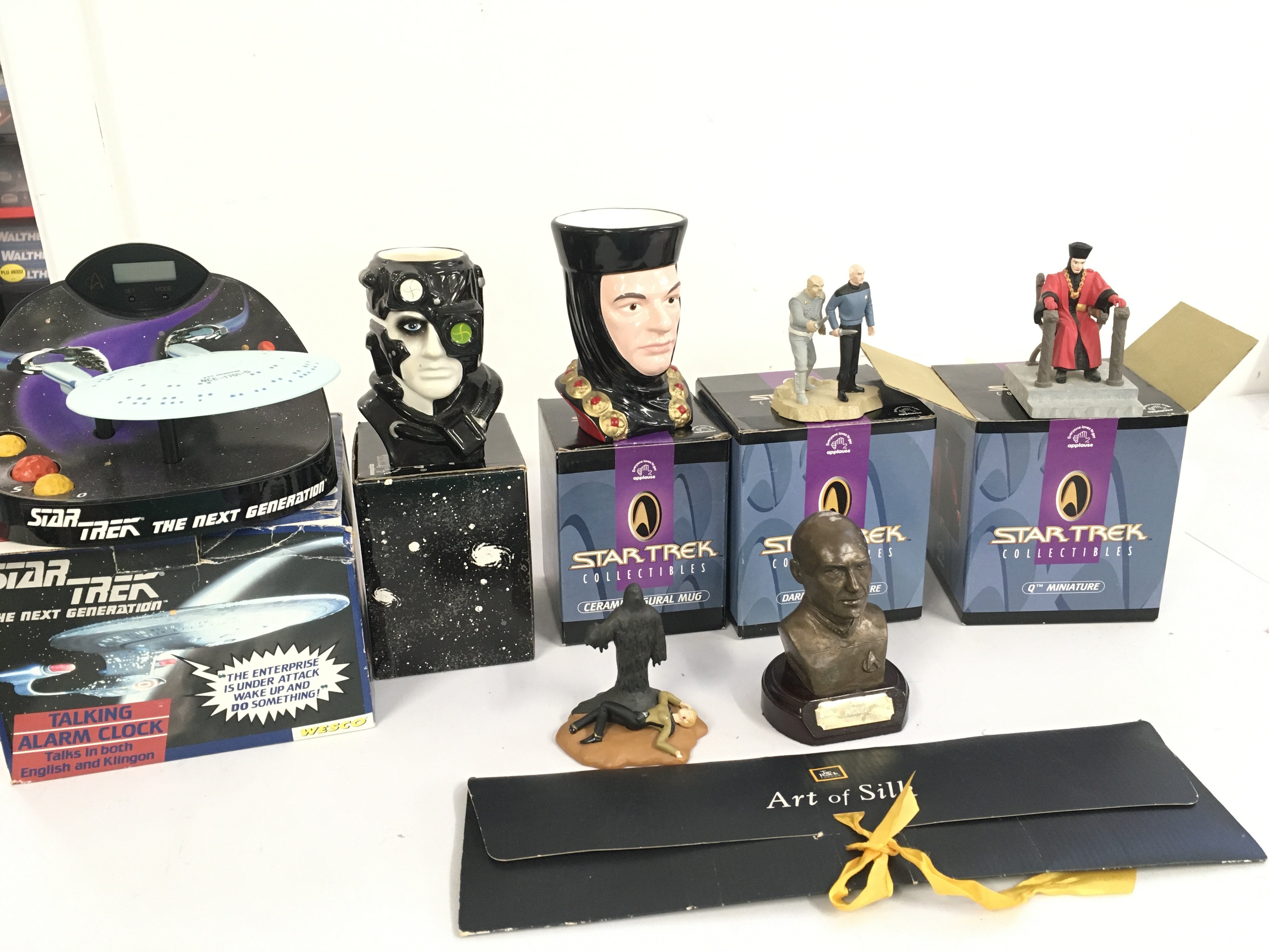 A collection of Star Trek pieces including a silk tie..an alarm clock..2 mugs..3 Minatures plus a Picard bust. No reserve