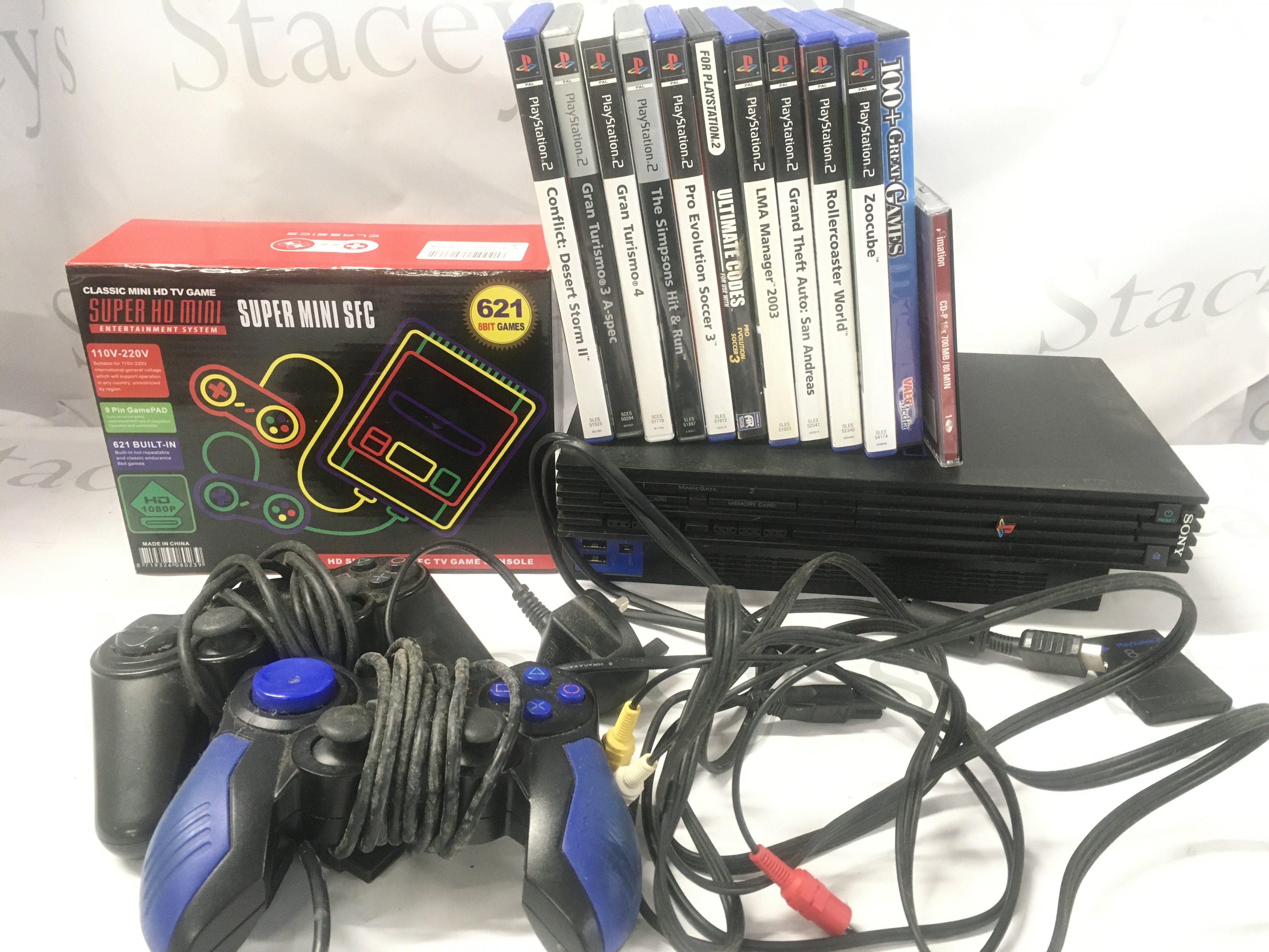 A Sony PlayStation 2. With Controllers. Games And A Boxed Super HD Mini Entertainment System.